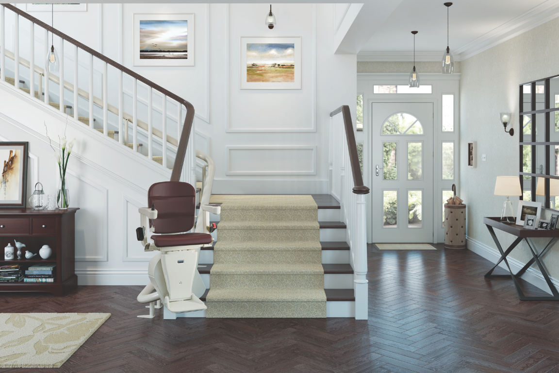 Entryway with stairs, a stairlift, artwork, and furniture in a well-lit home.