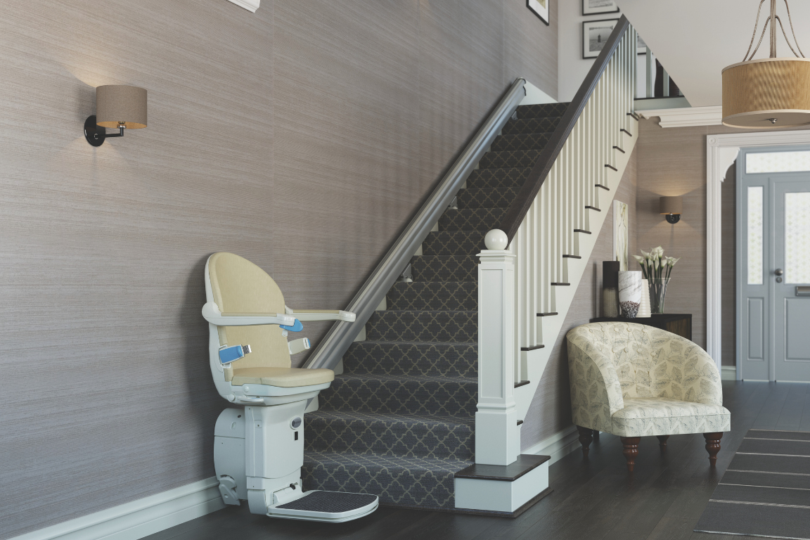 Home interior with staircase, beige armchair, and mounted wall lights.