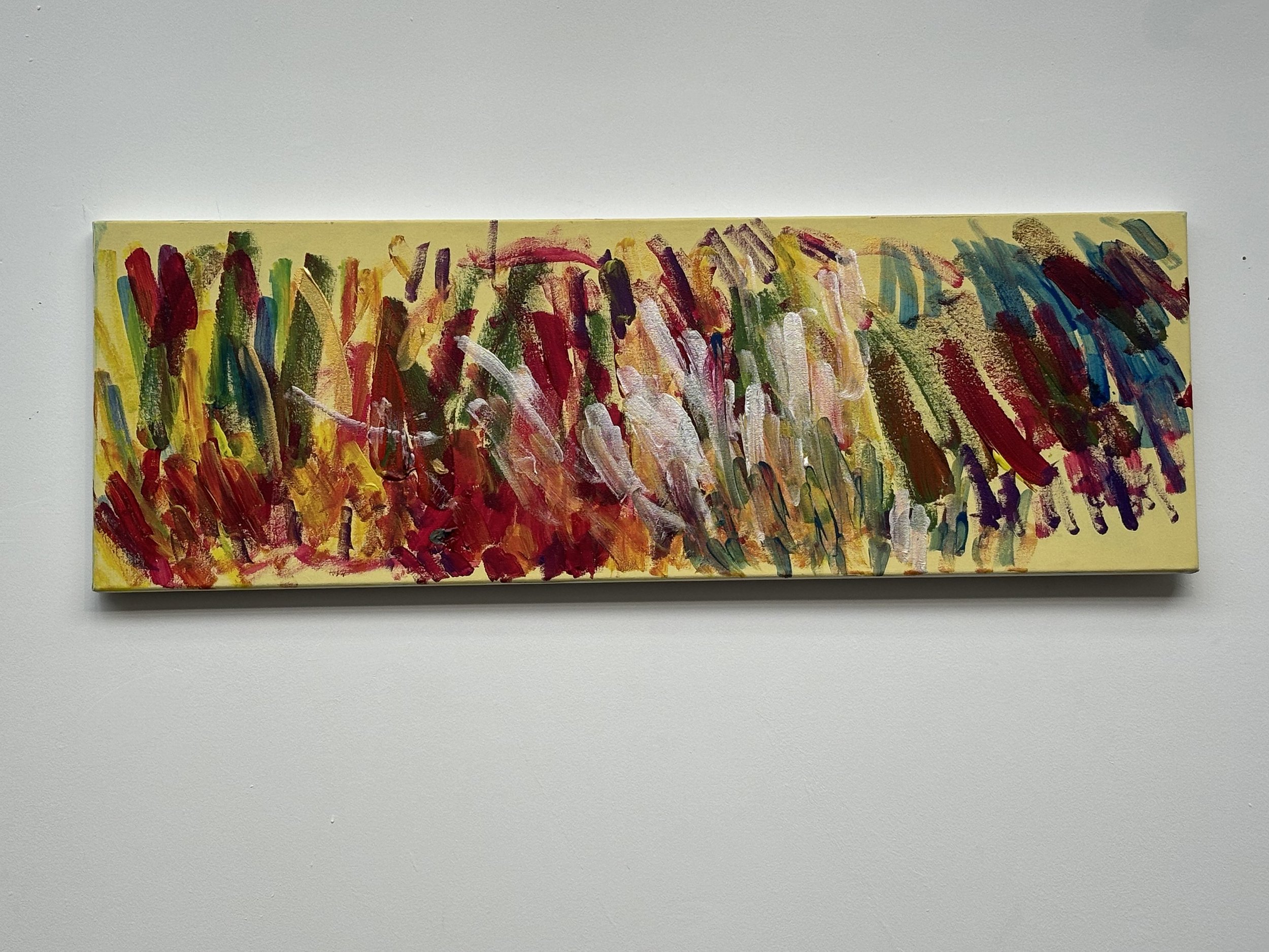 Abstract colorful acrylic painting with bold strokes of red, yellow, green, purple, blue, and white on a rectangular canvas.
