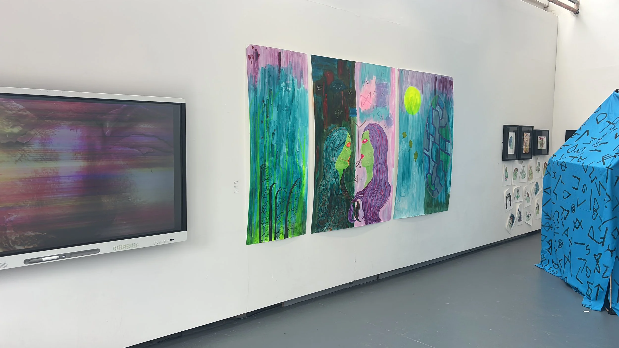 Art gallery wall with colorful paintings depicting abstract and surreal figures, a television screen, and a blue fabric with black symbols on the right.