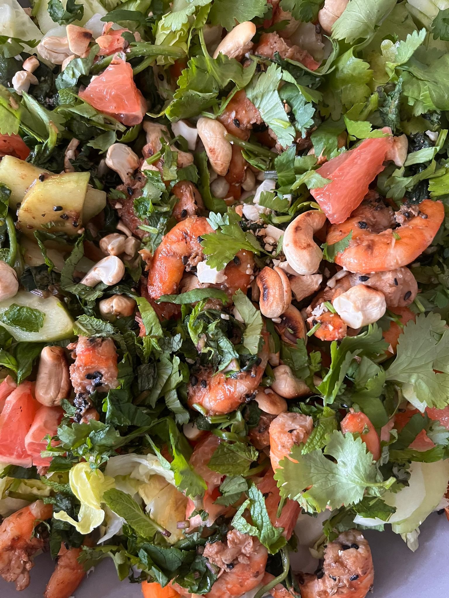 Salade avec des crevettes, avocats, tomates, coriandre, champignons et noix.