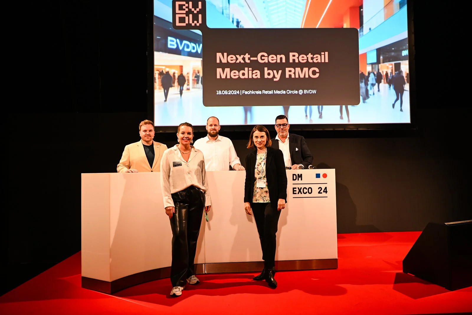 Bühne mit fünf Personen vor einem großen Bildschirm, der Text zeigt: 'Next-Gen Retail Media by RMC, 18.09.2024, Fachkreises Retail Media Circle @ BVDW', bei einer Konferenz im Expo 24 in Deutschland.