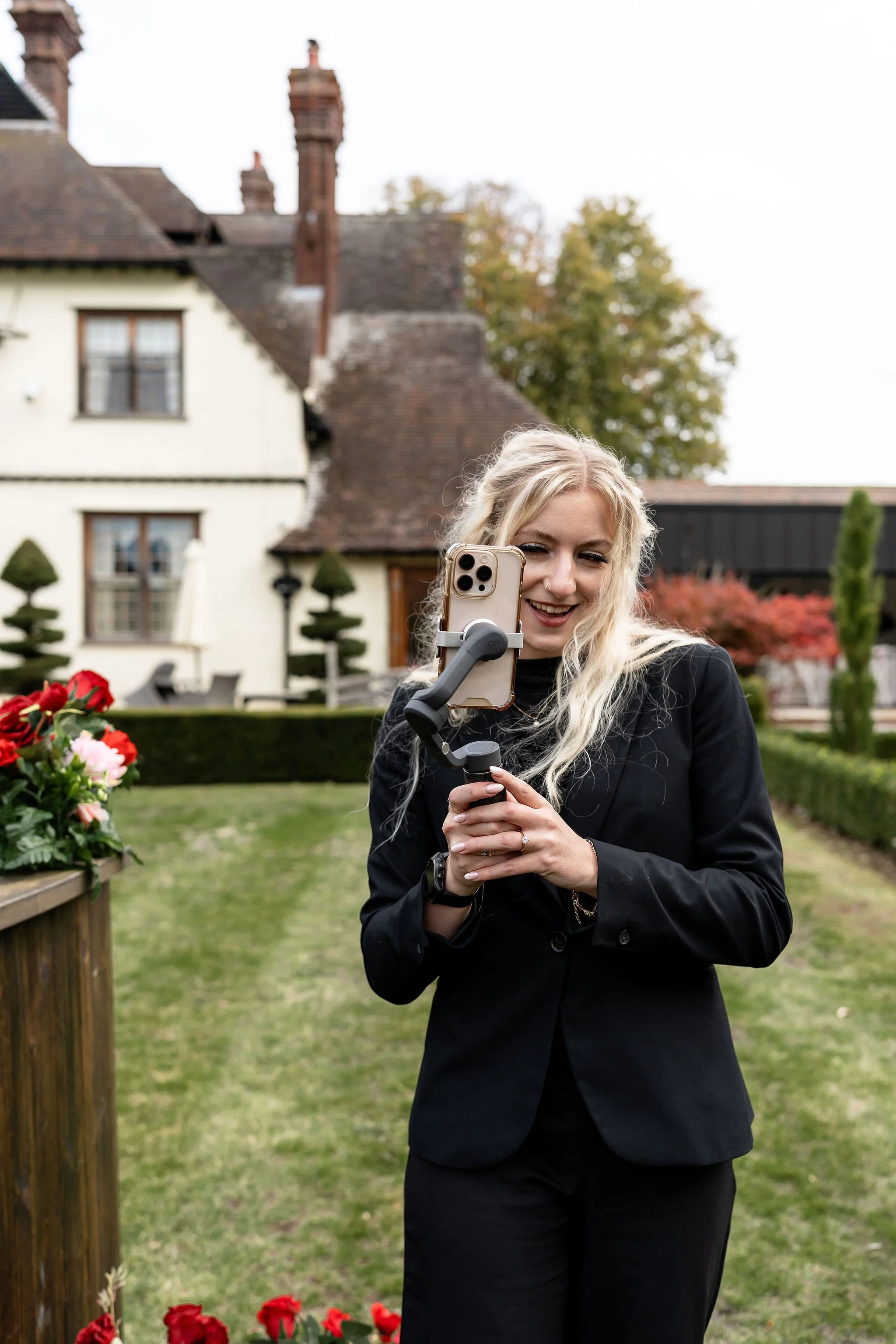 Lady holding a mobile phone creating and capturing special moments from a wedding shoot 