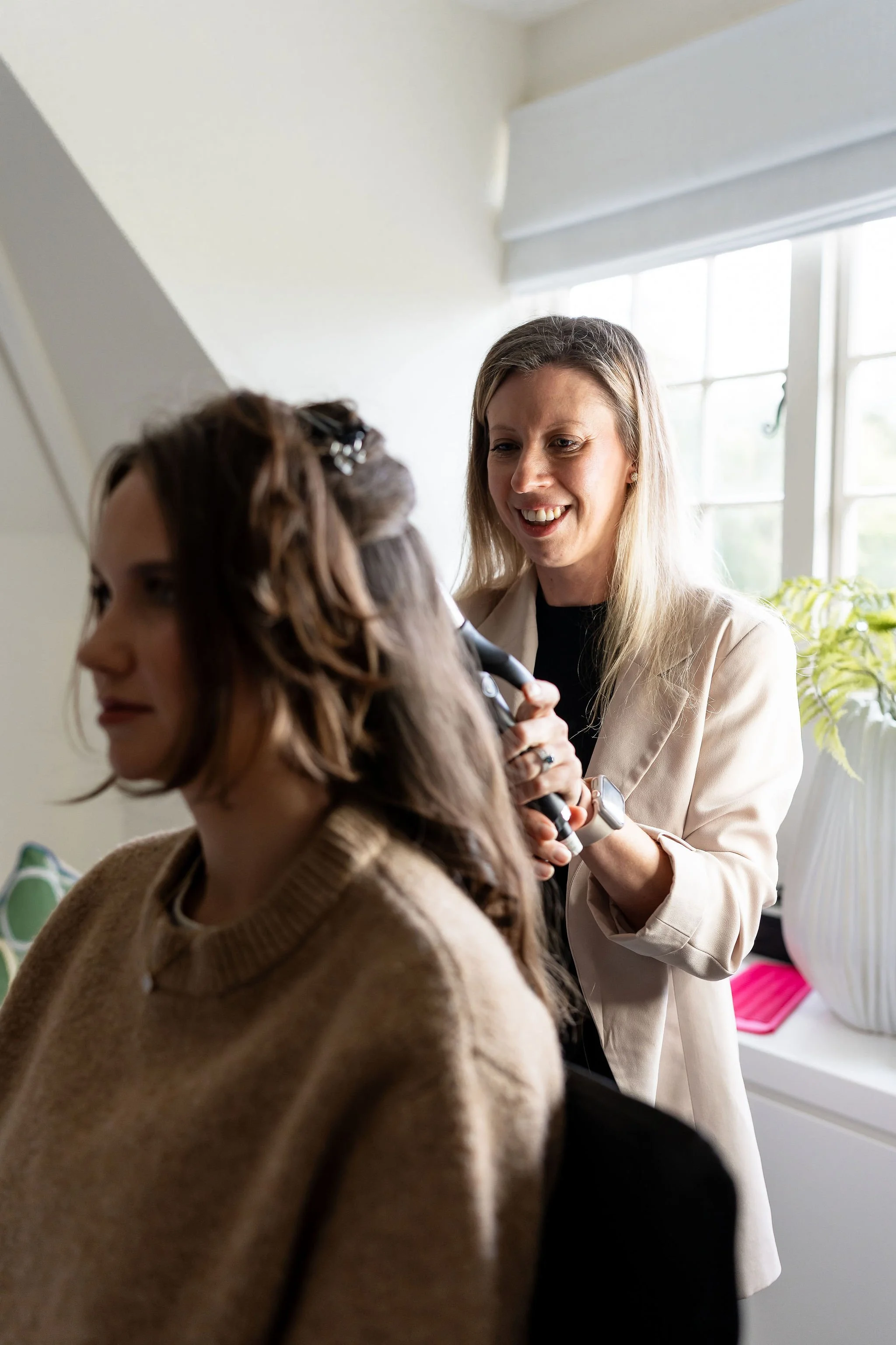 Laura styling a brides hair with curling tongs