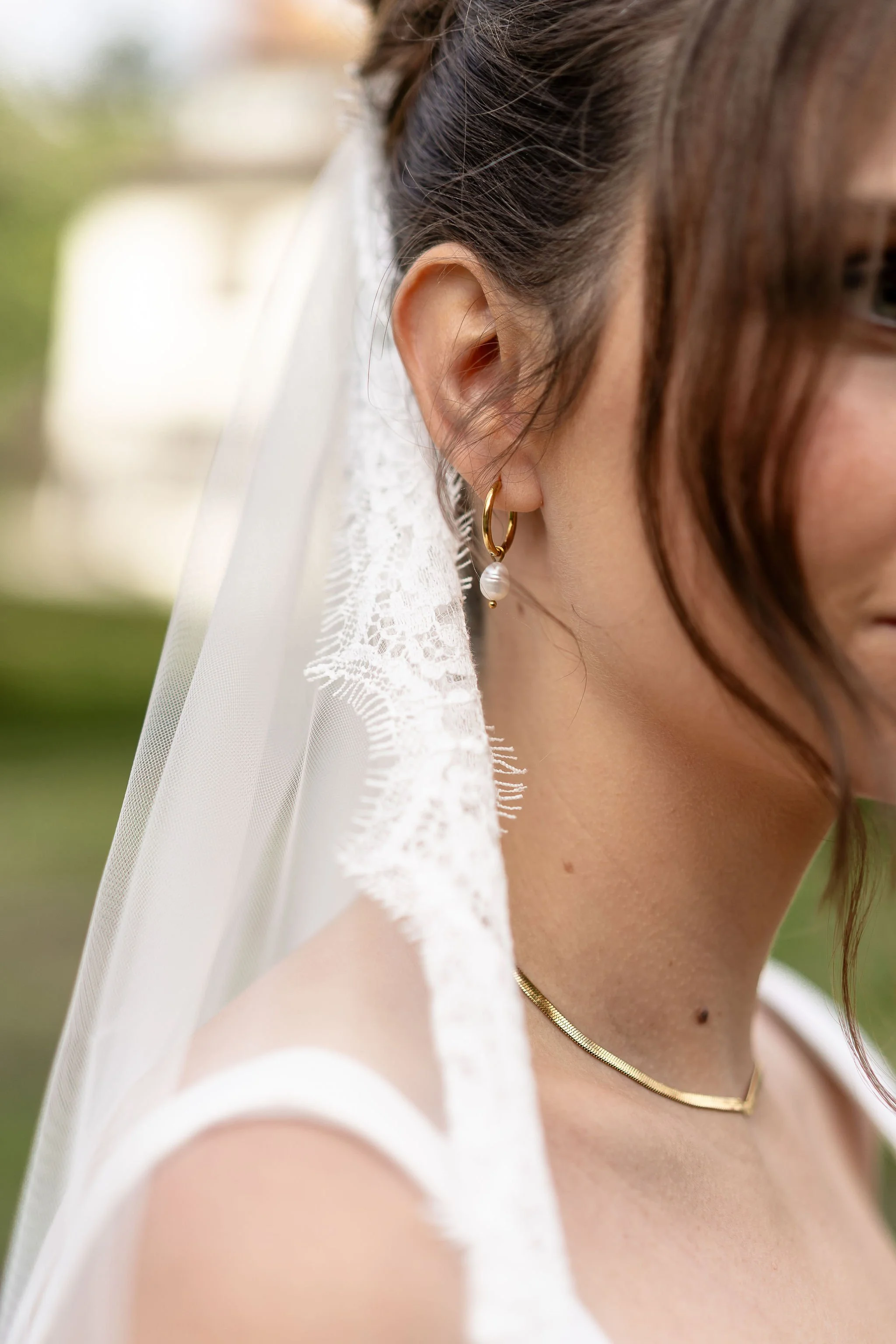 Close up of a gold drop earring a bride is weaing