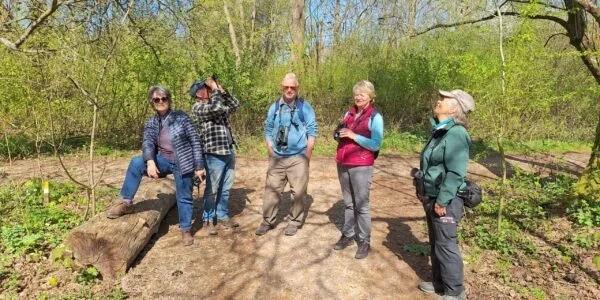 Five Henfield Birdwatchers in a wooded area during daytime.