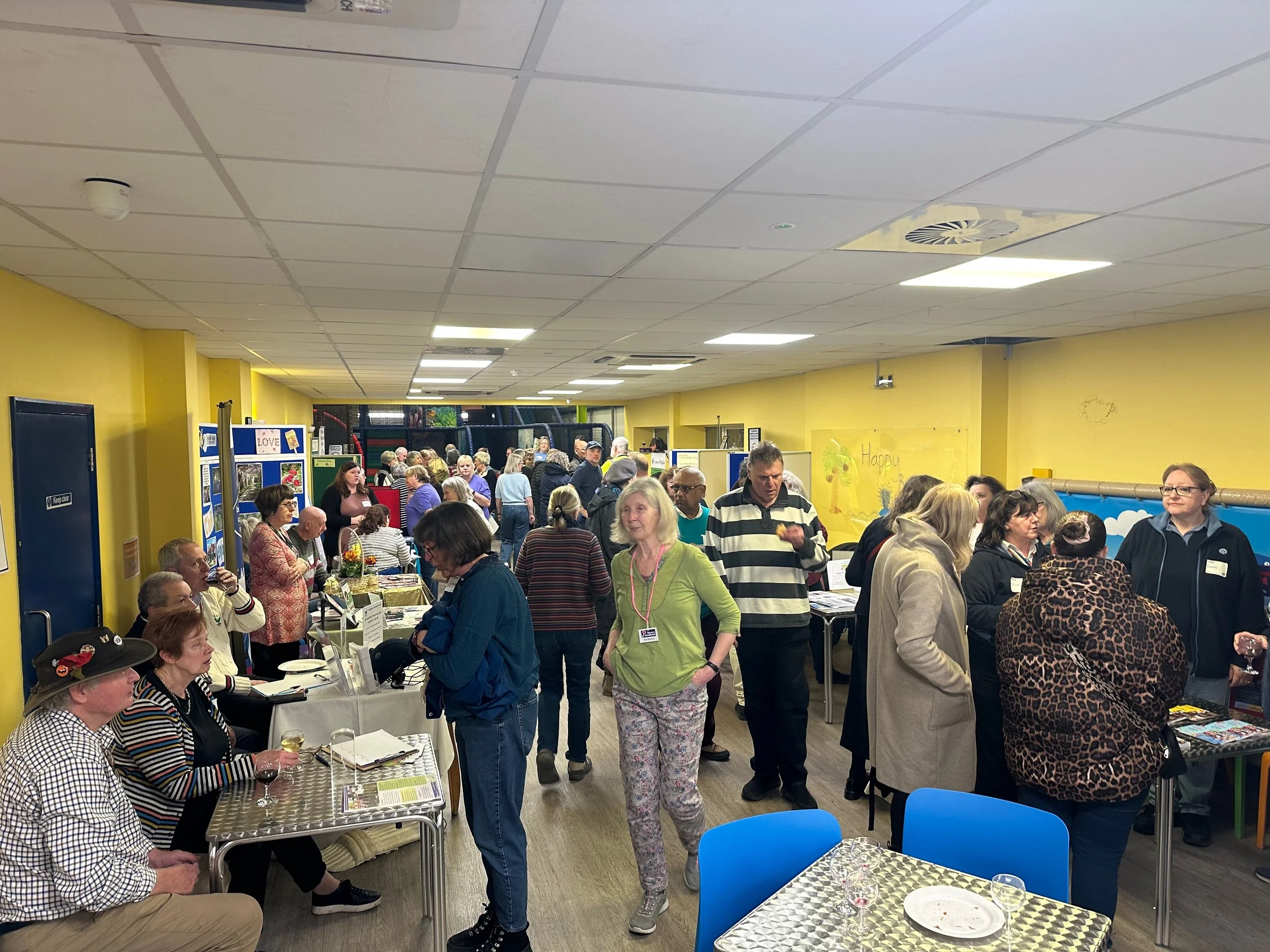 A large group of people at Henfield Leisure Centre visiting stalls of voluntary organisations