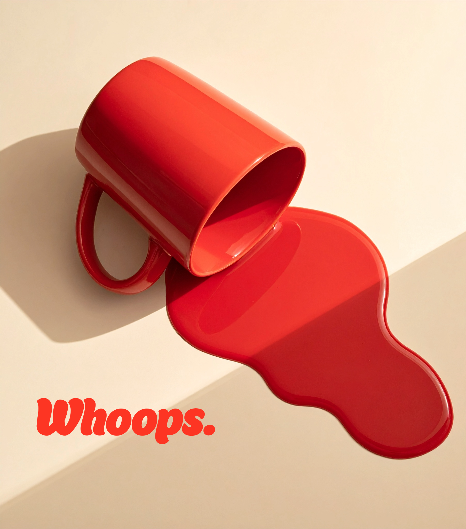 A red mug tipped over with spilled red liquid on a white surface. The word "Whoops." is written in red near the bottom left corner.