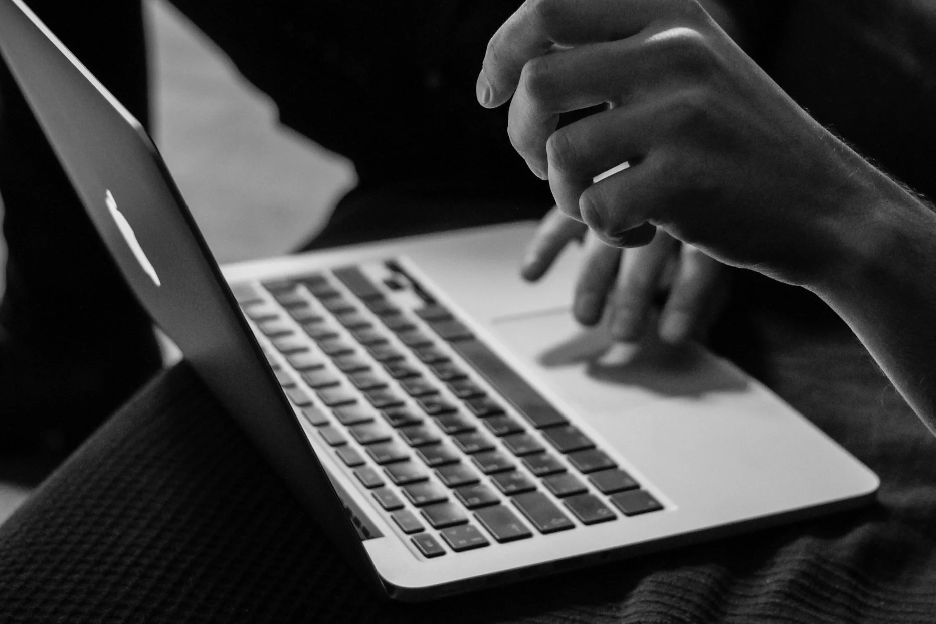 Person using a laptop with focus on hands and keyboard