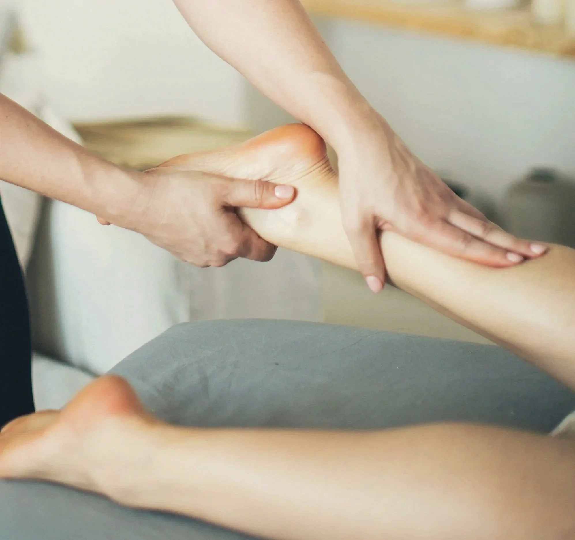Close-up of a person's hand holding a baby's foot.