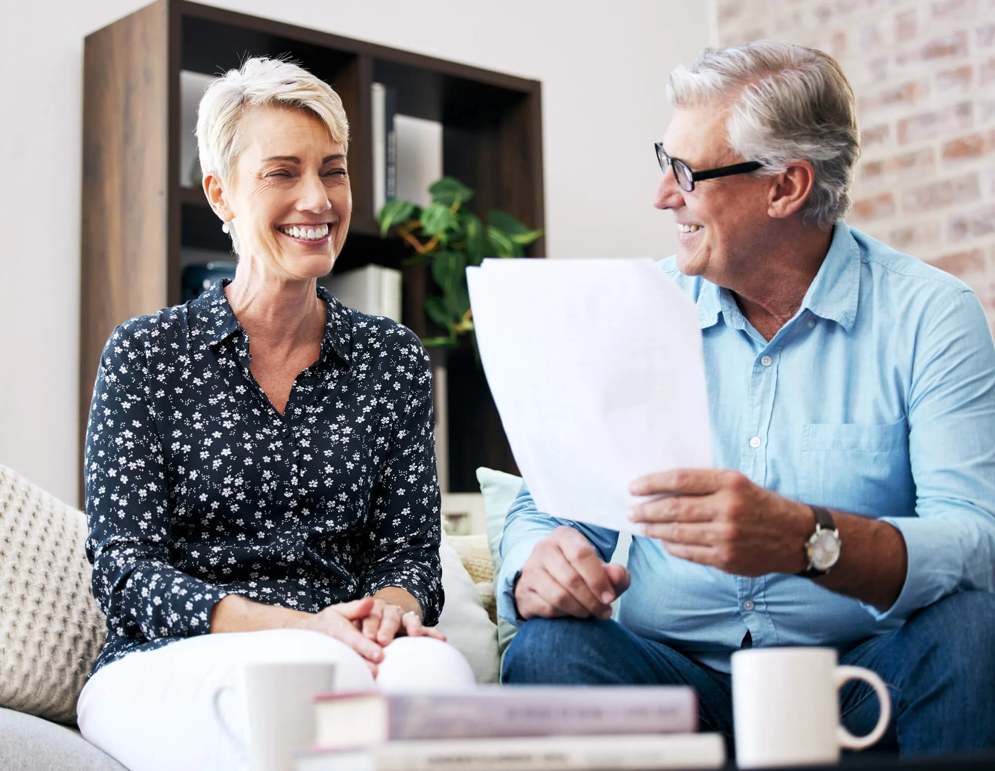 Retired couple smiling looking at paperwork