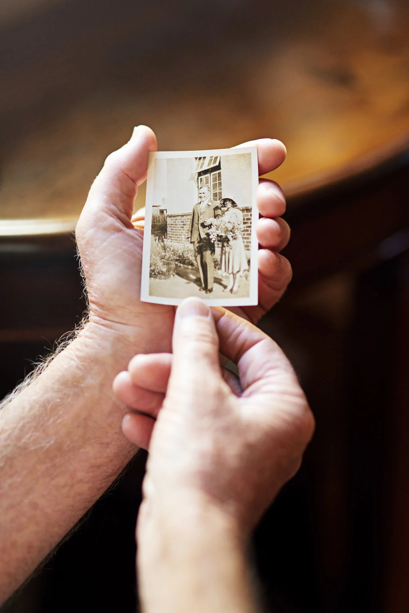 Close up of hands holding a black and white family photograph