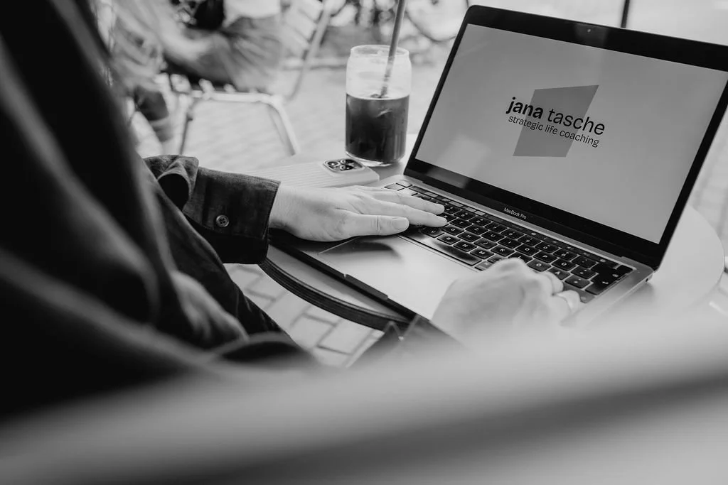 Jana Tasche arbeitet am Laptop mit Markenlogo auf dem Bildschirm