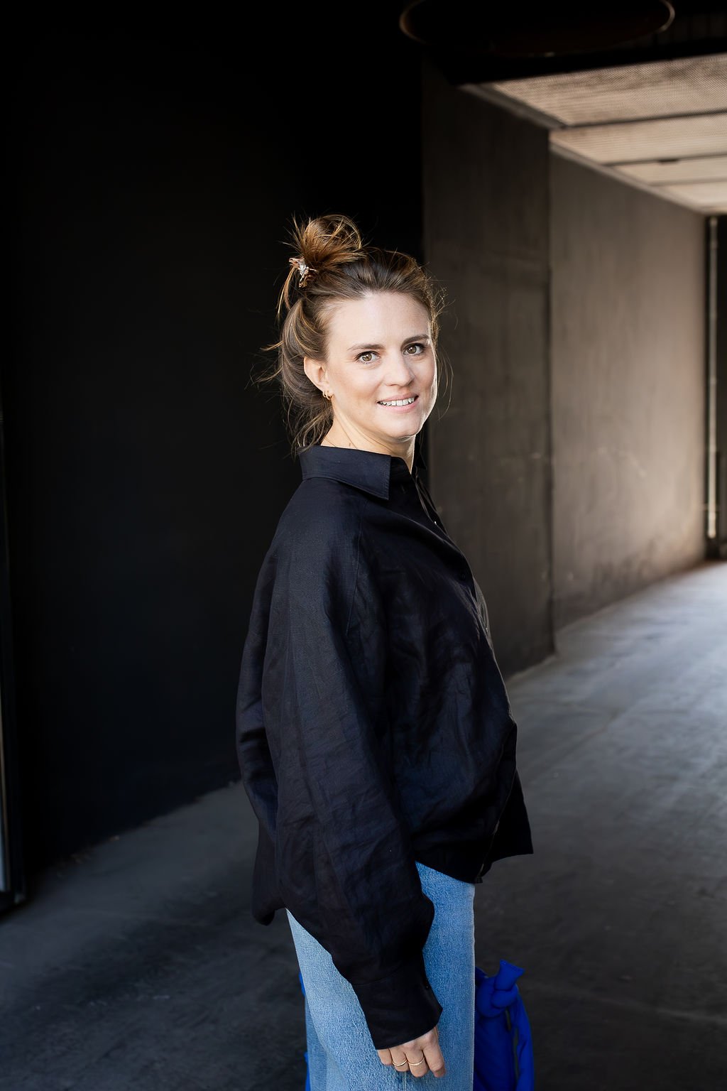 Jana Tasche lächelnd vor dunklem Hintergrund - Strategic Life Coach