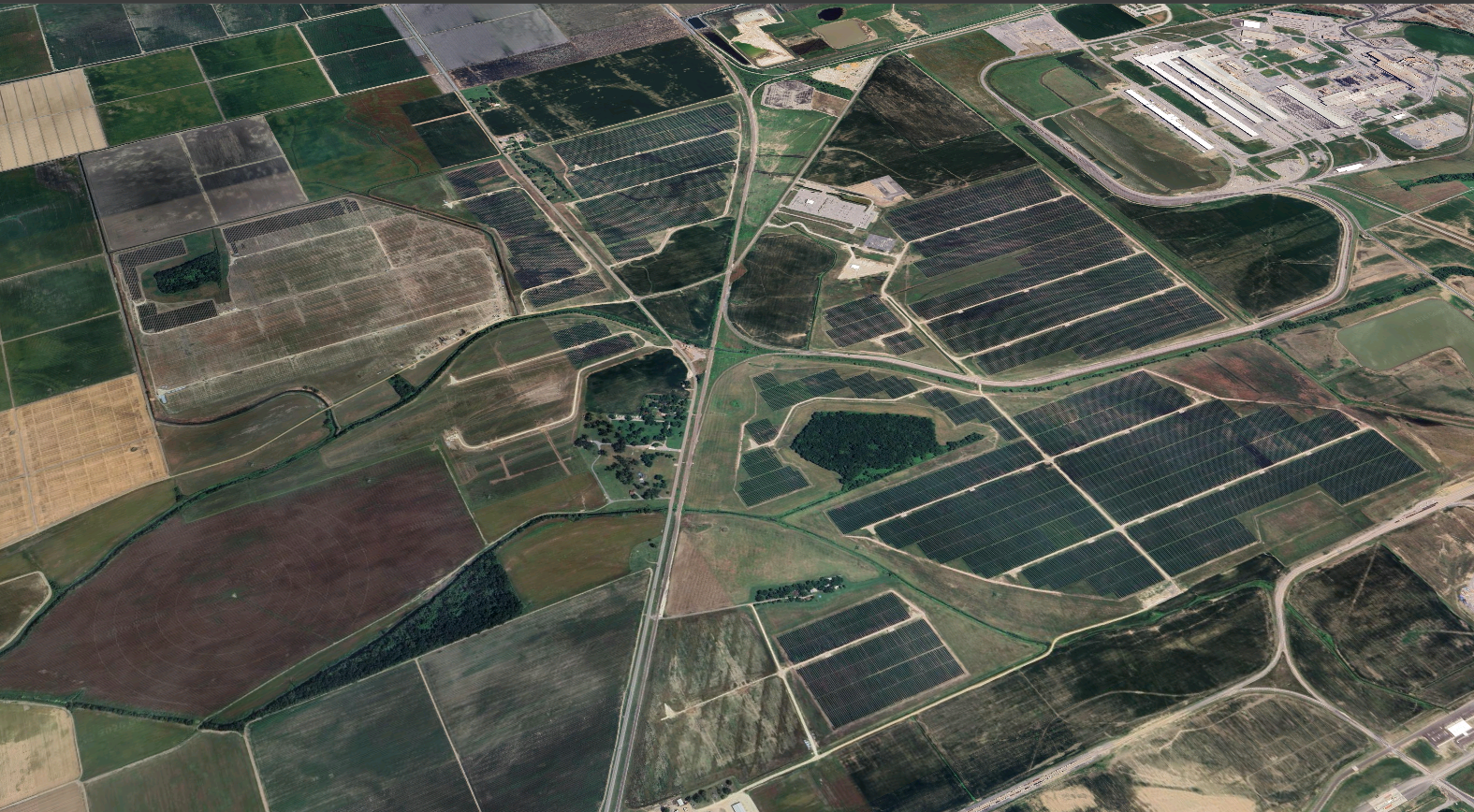 Aerial view of farmland with fields, roads, and solar panel installations. Revamp Engineering Texas Solar project