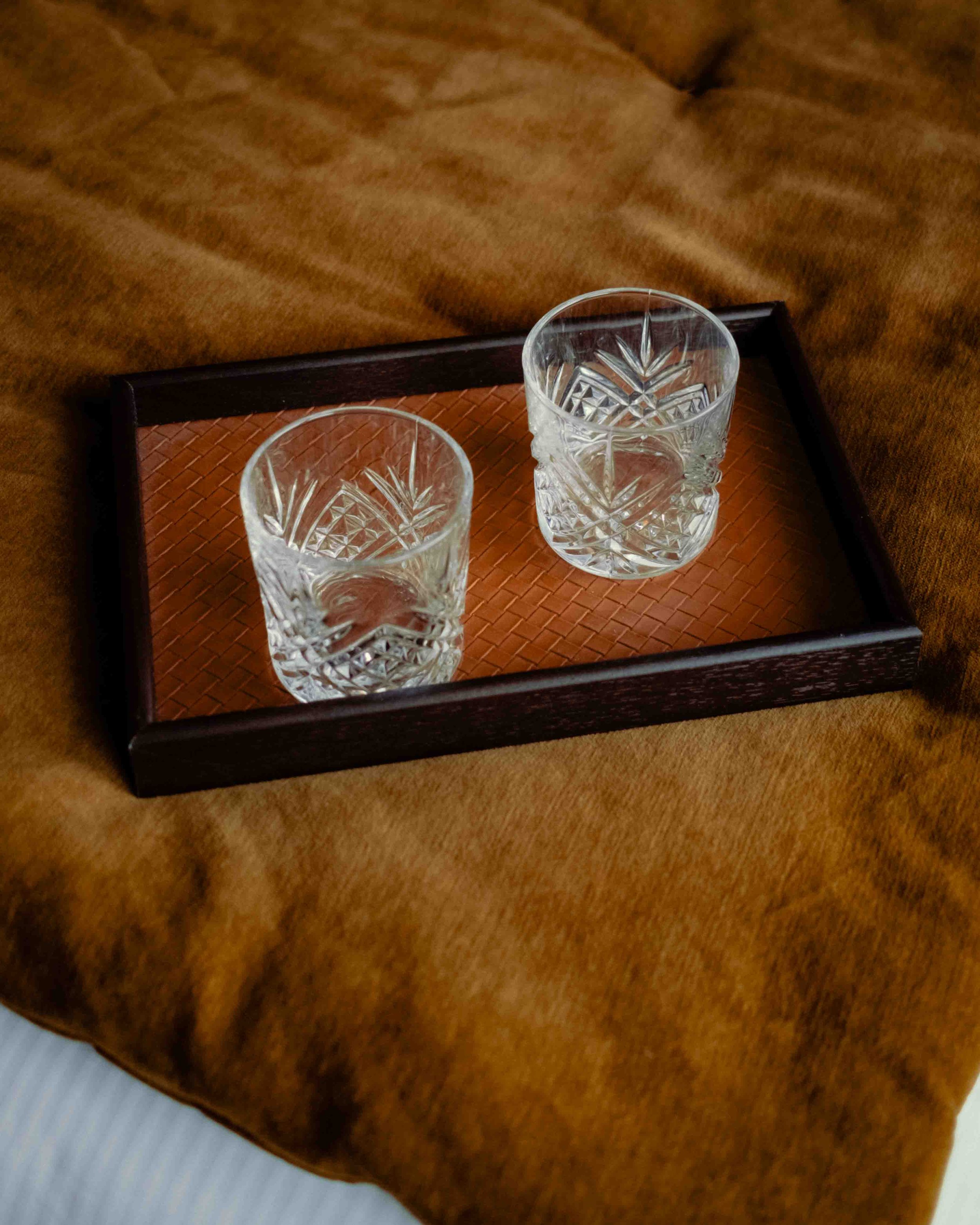 photo d'un coin de lit au Markus Coffee avec deux verre a whisky dans un plateau