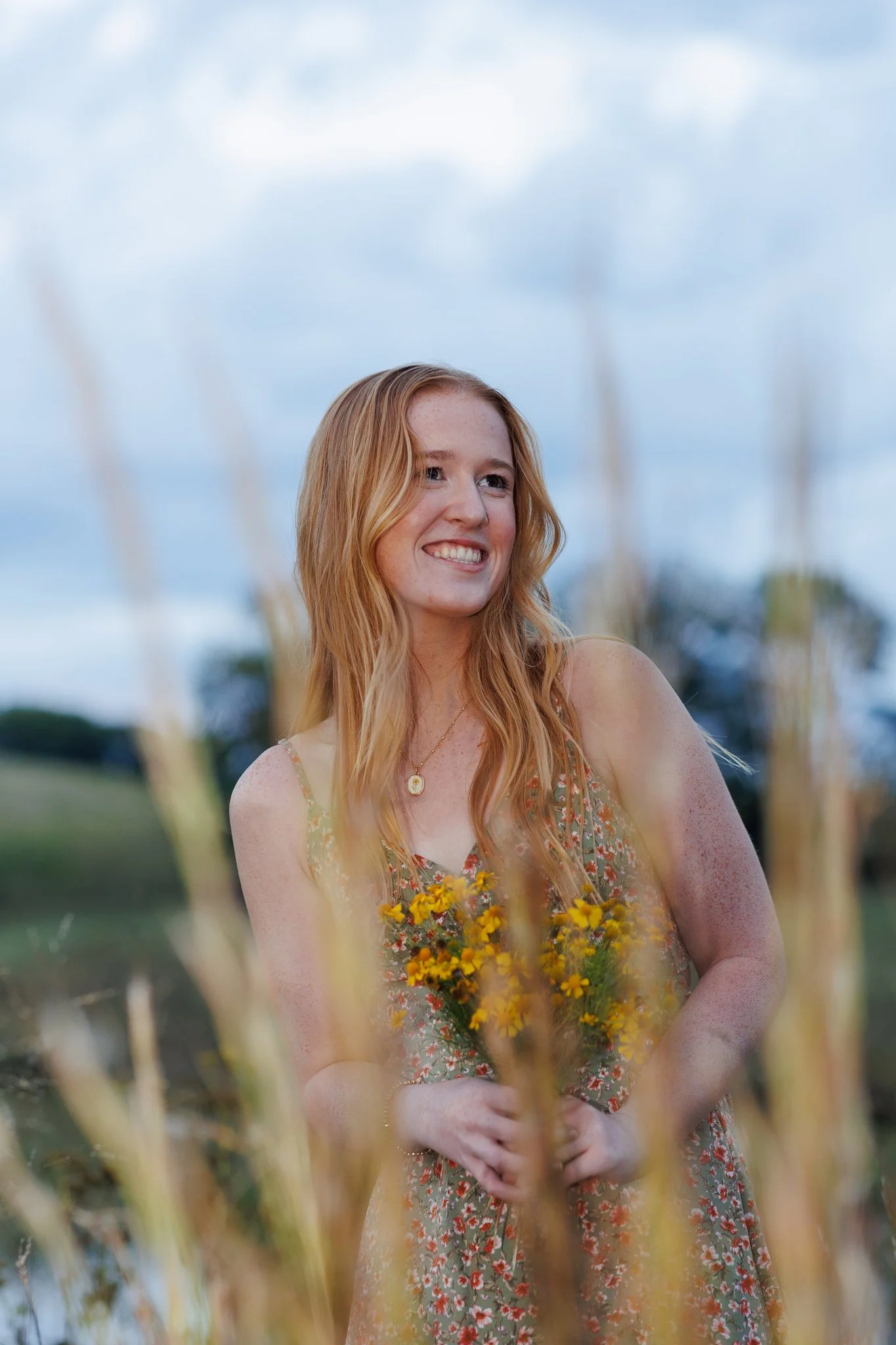 High school senior portrait holding wildflowers at Strong Stock Farm in Knoxville, Tennessee.