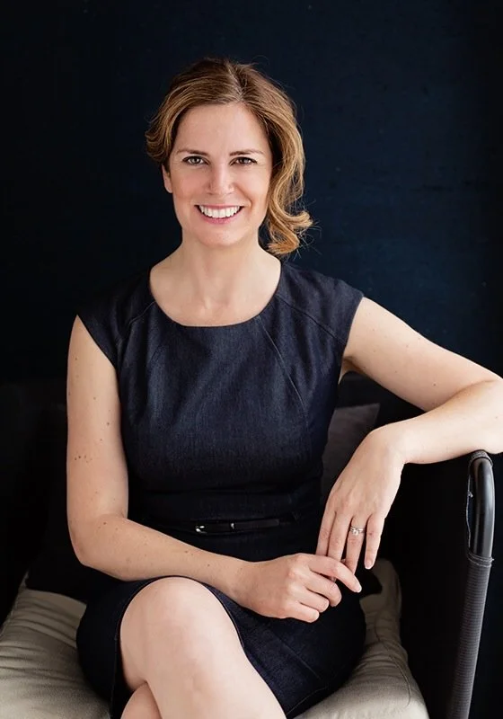 Potrait Photograph of Rachel Jele (She/Her), Head of Advocacy and Engagement, smiling with brown hair, wearing a black dress