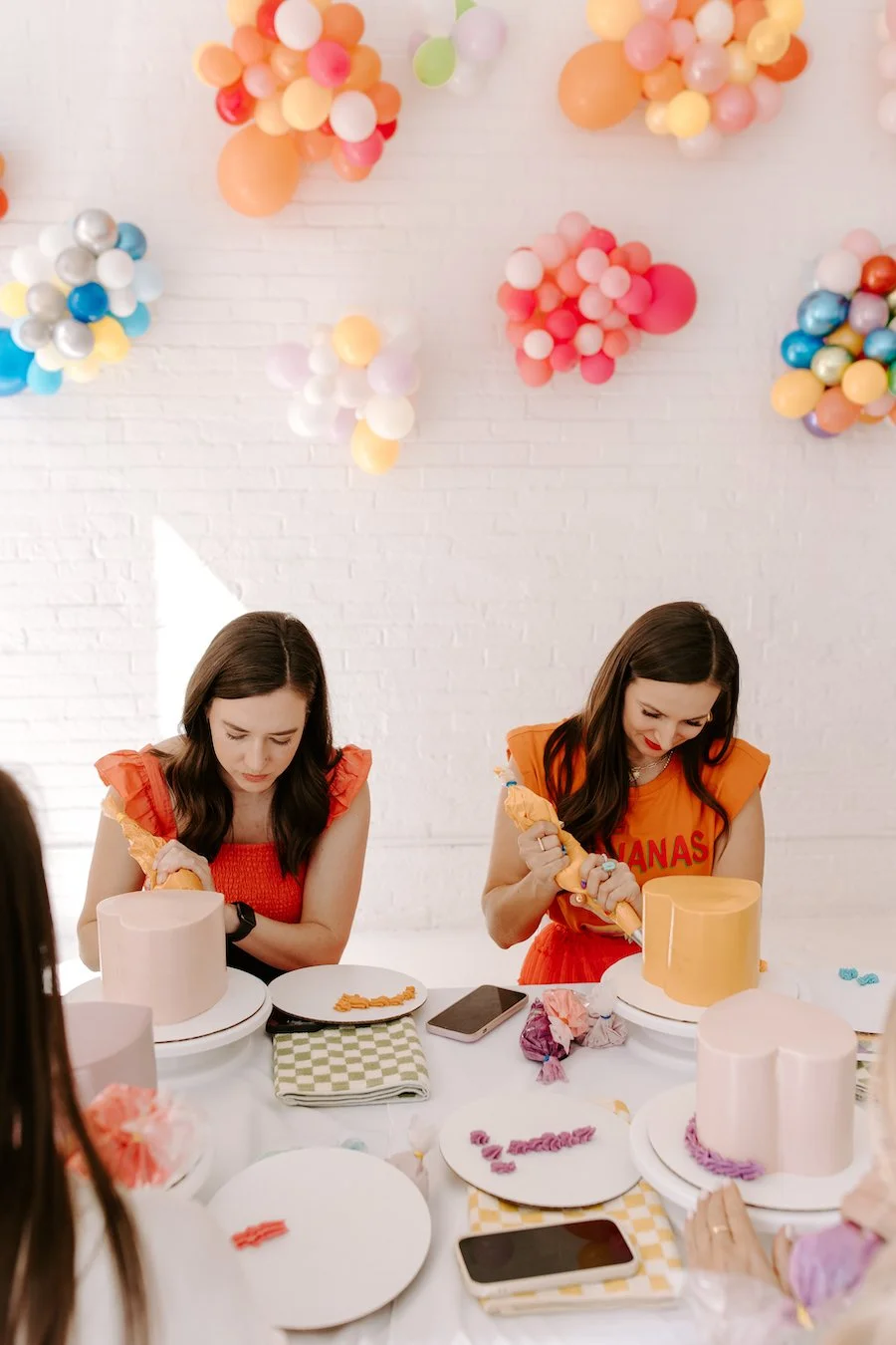 cake decoration accessories - women piping frosting onto cakes