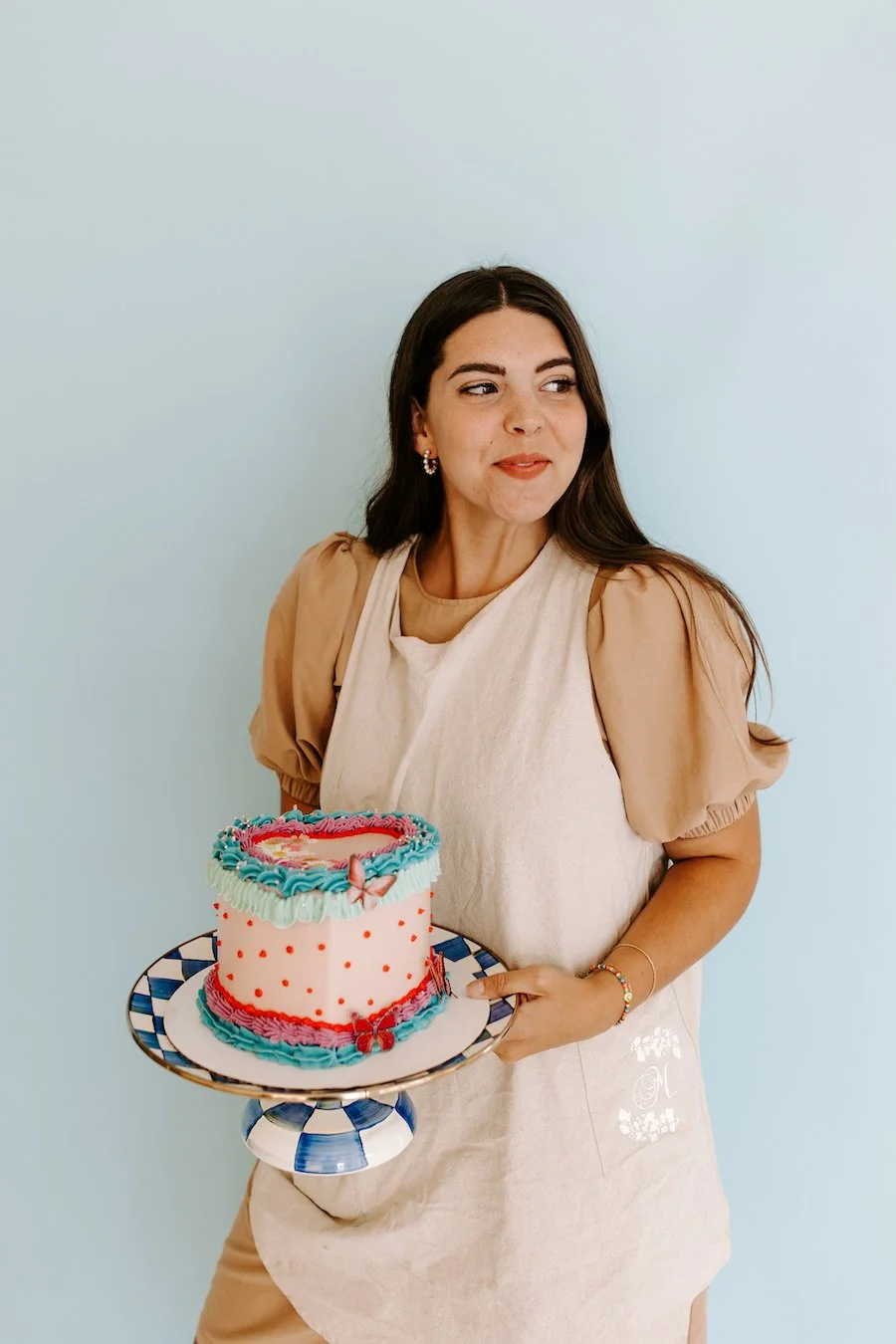 cake decoration accessories - woman holding frosted and decorated cake