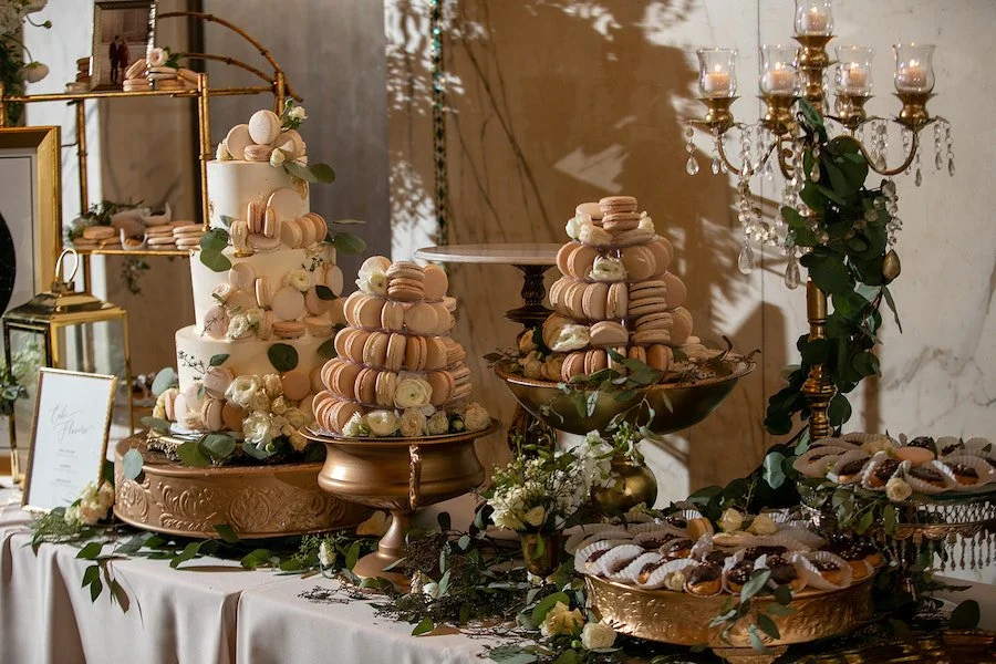 cake frosting types - frosted cake and filled macarons on a wedding reception dessert table