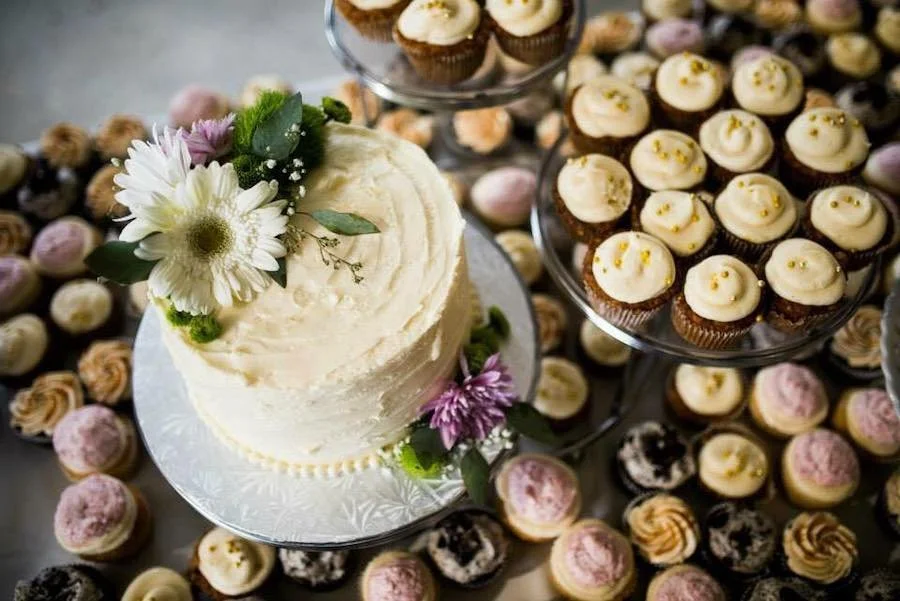 how many people does an 8-in cake feed? an overhead shot of a small decorated cake surrounded by cupcakes