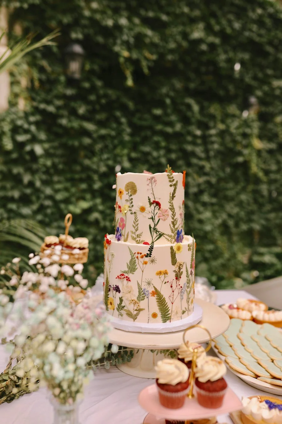 how to decorate a cake with flowers - pressed wedding cake with cupcakes on the table
