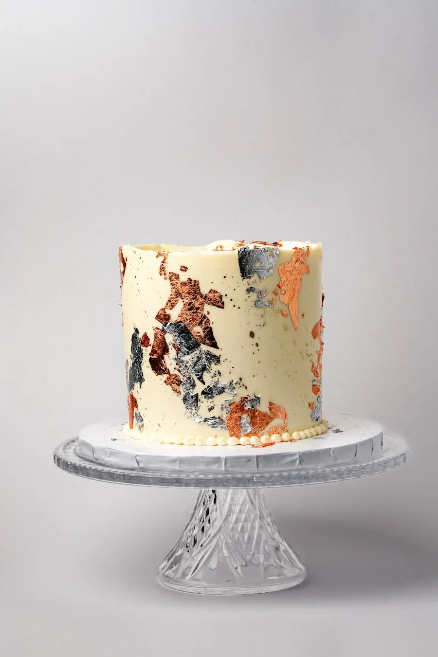 how to make a dummy cake - cake decorated with patches of metallic edible foil
