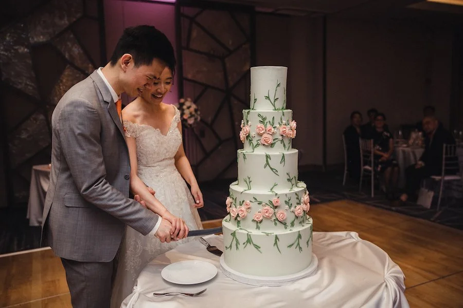 how to make buttercream flowers - cutting a cake decorated with buttercream flowers