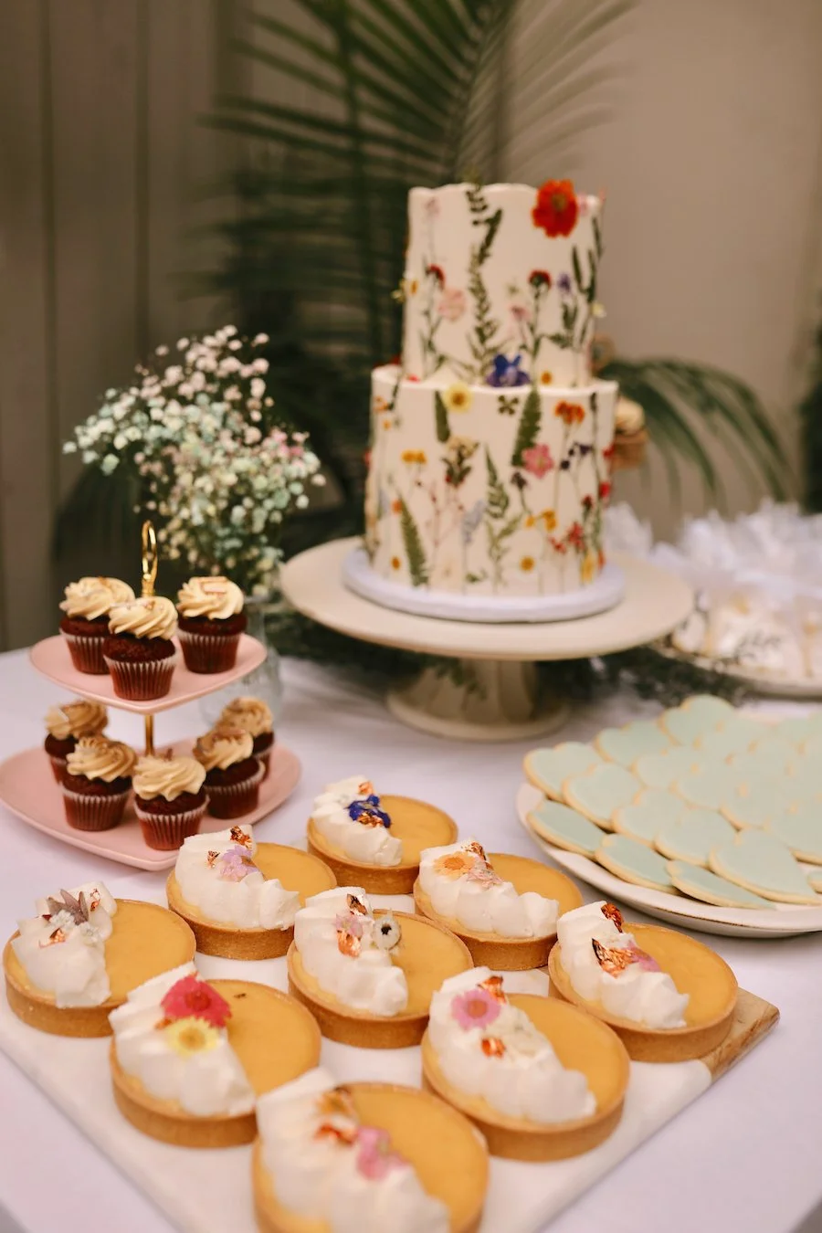 rustic wedding cake ideas - wedding cake with pressed flowers and a dessert table