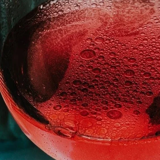 Close-up of a glass of red wine with condensation and bubbles on the surface