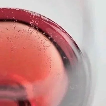 Close-up of a glass of red wine with condensation on the outside of the glass.