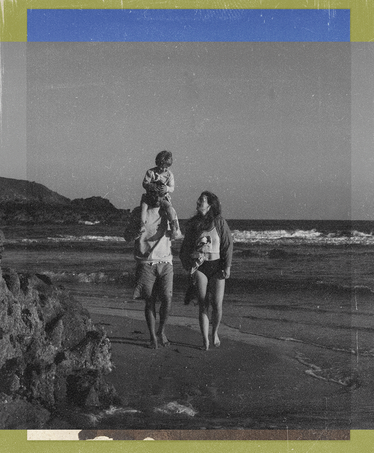 A black and white photo of a family at the beach. A man is walking with a woman, and a child is sitting on the man's shoulders, all enjoying the seaside view at sunset or daytime.
