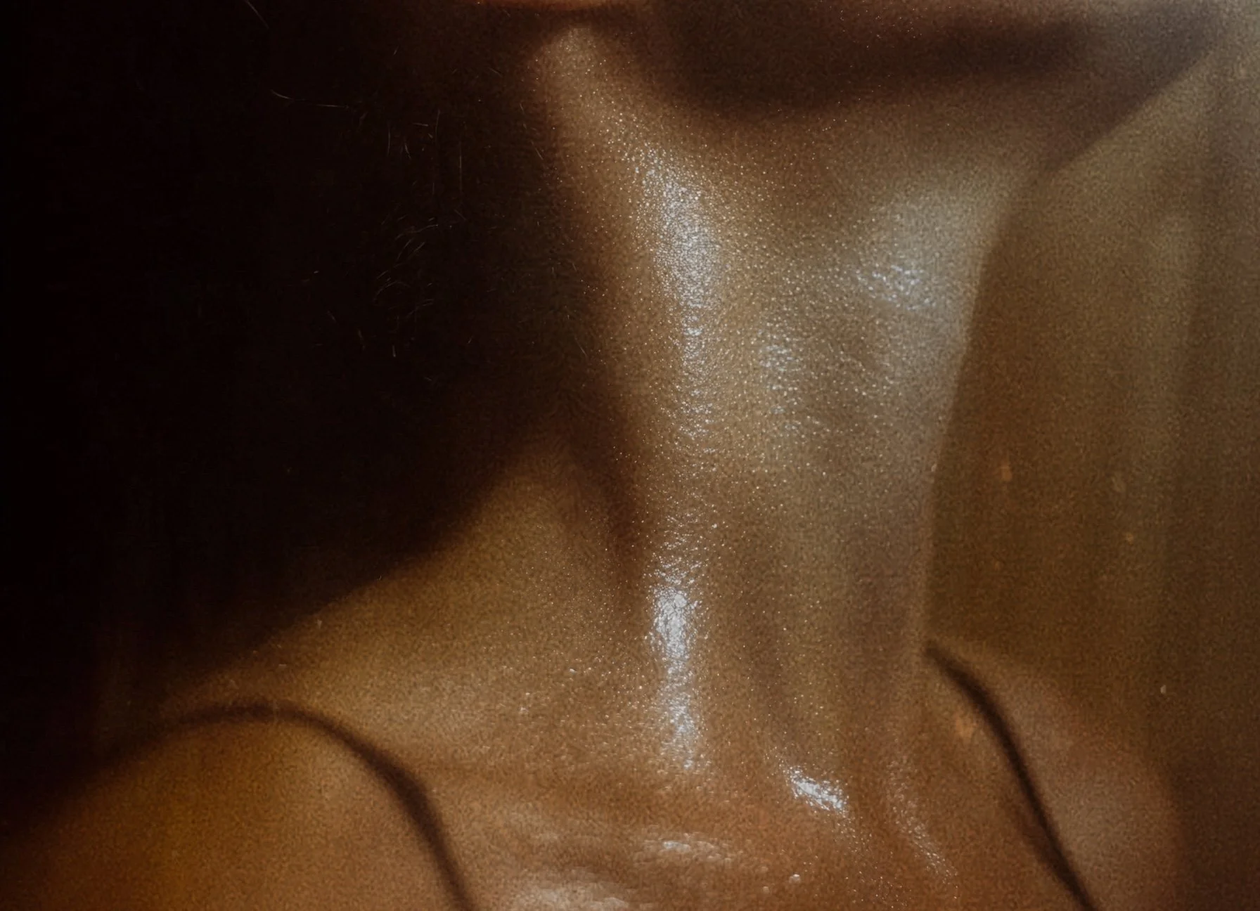 Close-up of a person's face with a shiny, reflective surface, showing skin texture and facial features.