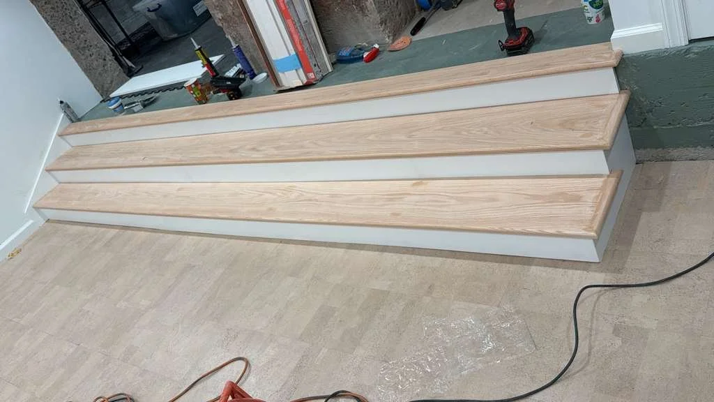 Construction site with wooden stairs and construction tools and materials in the background.