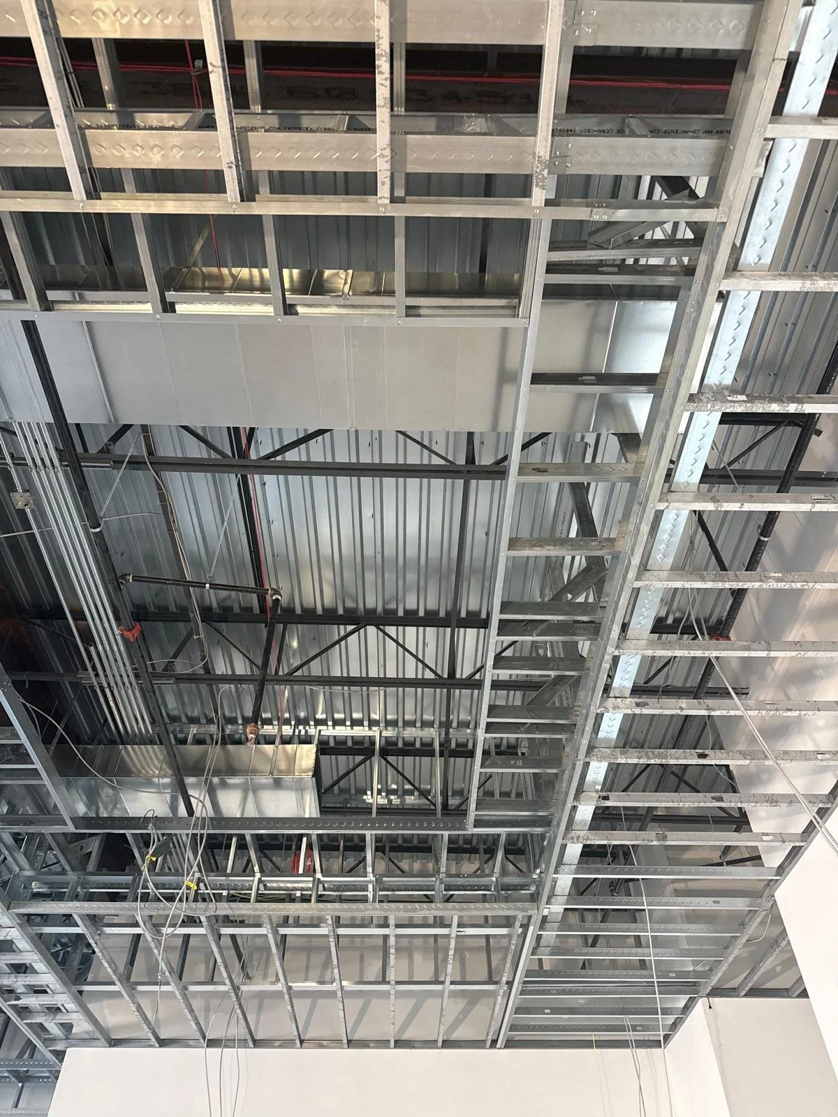 Metal framework and ductwork for ceiling installation in building construction.