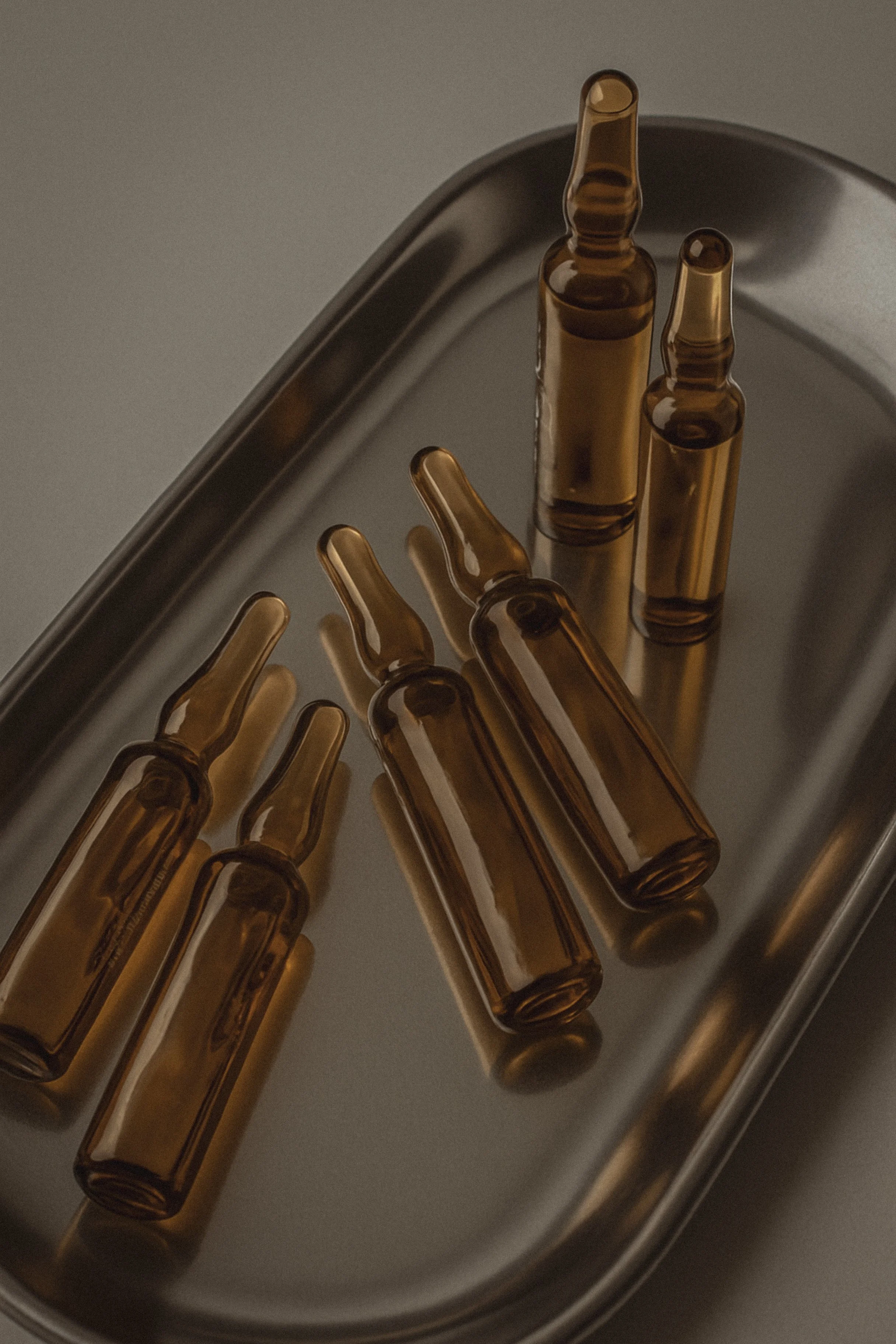 Several brown glass ampoules on a stainless steel tray.