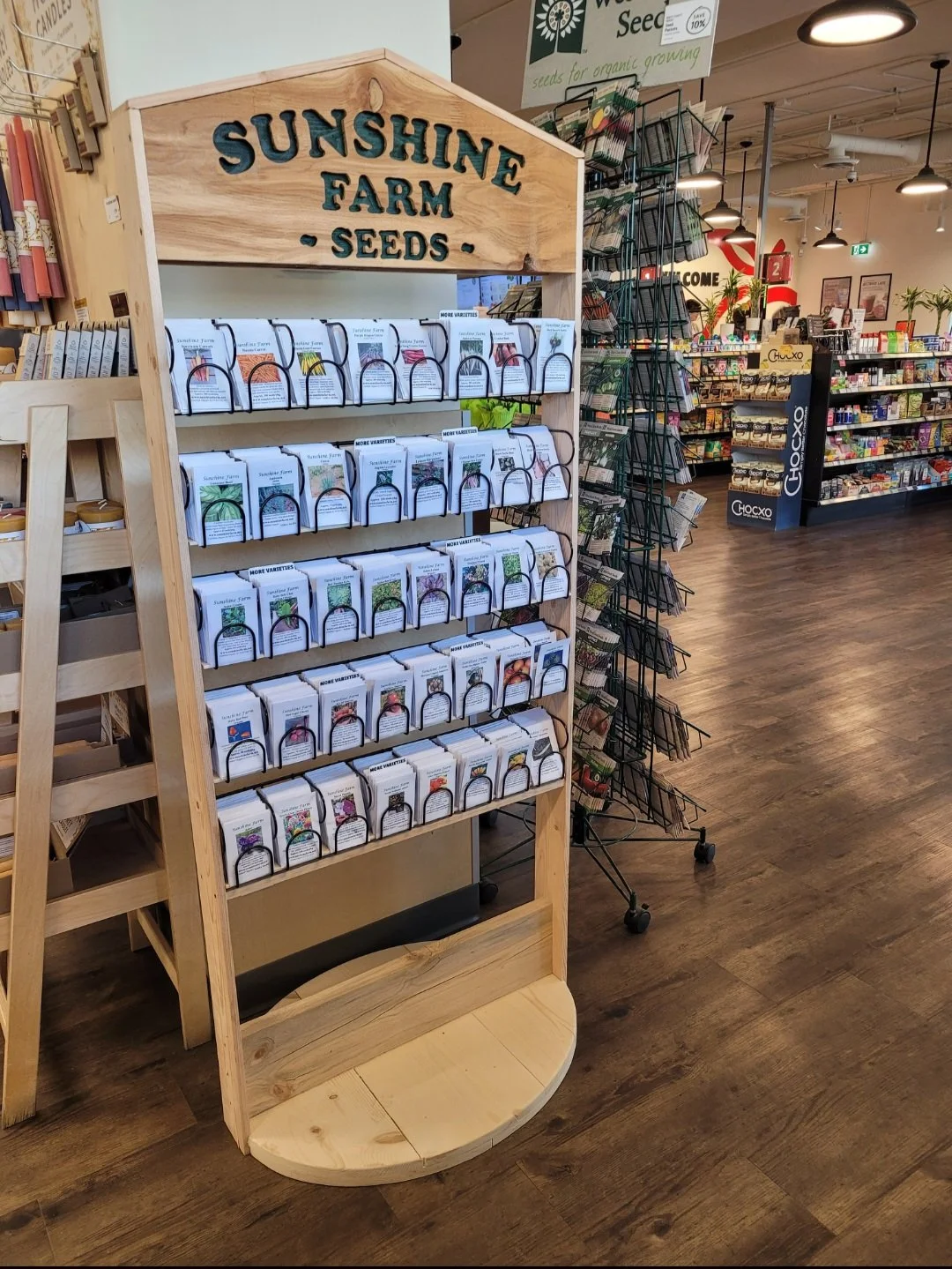 Display rack of seed packets labeled 'Sunshine Farm Seeds' at a garden center or store.