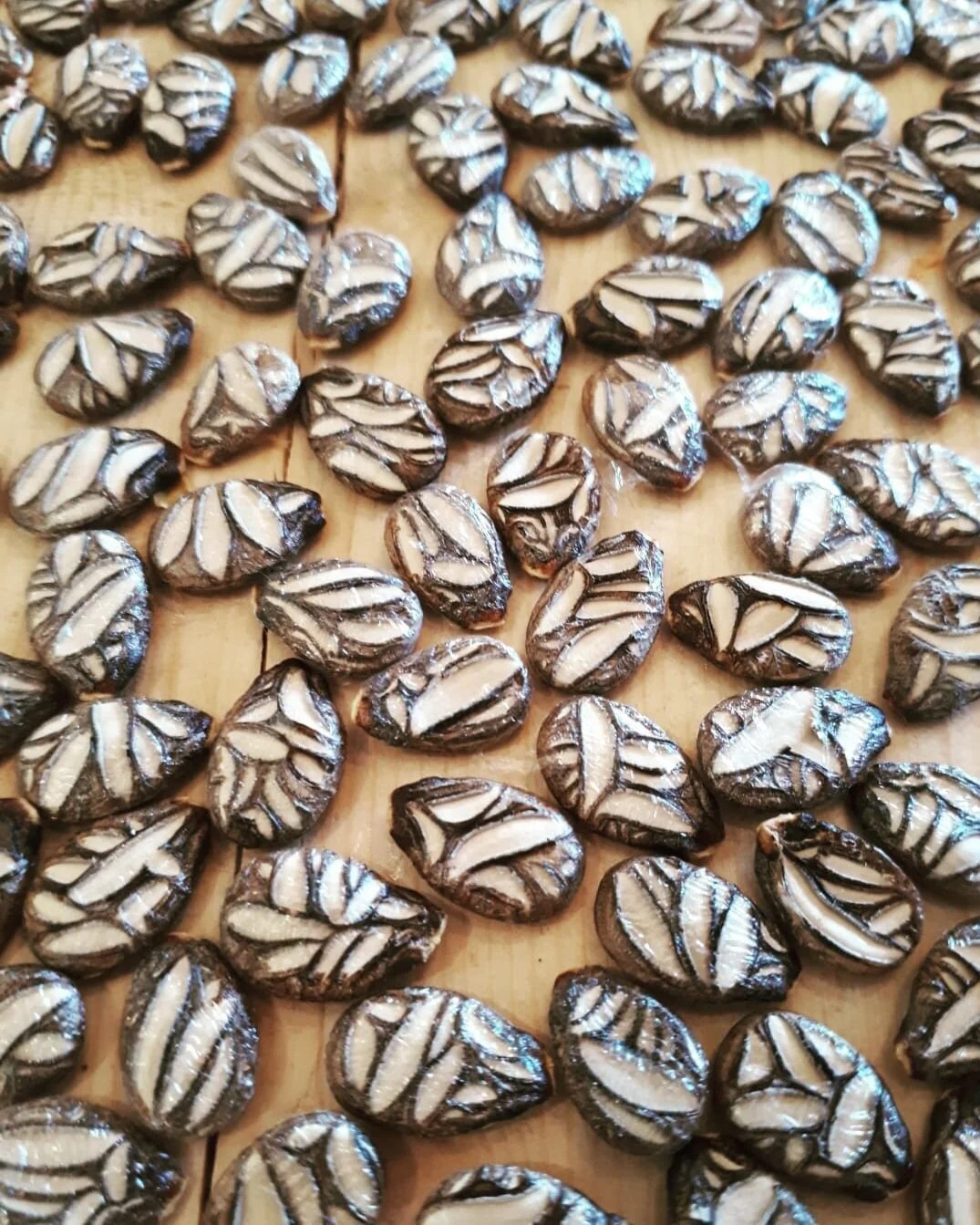 Close-up of striped, chocolate-covered cookies or candies arranged on a wooden surface.