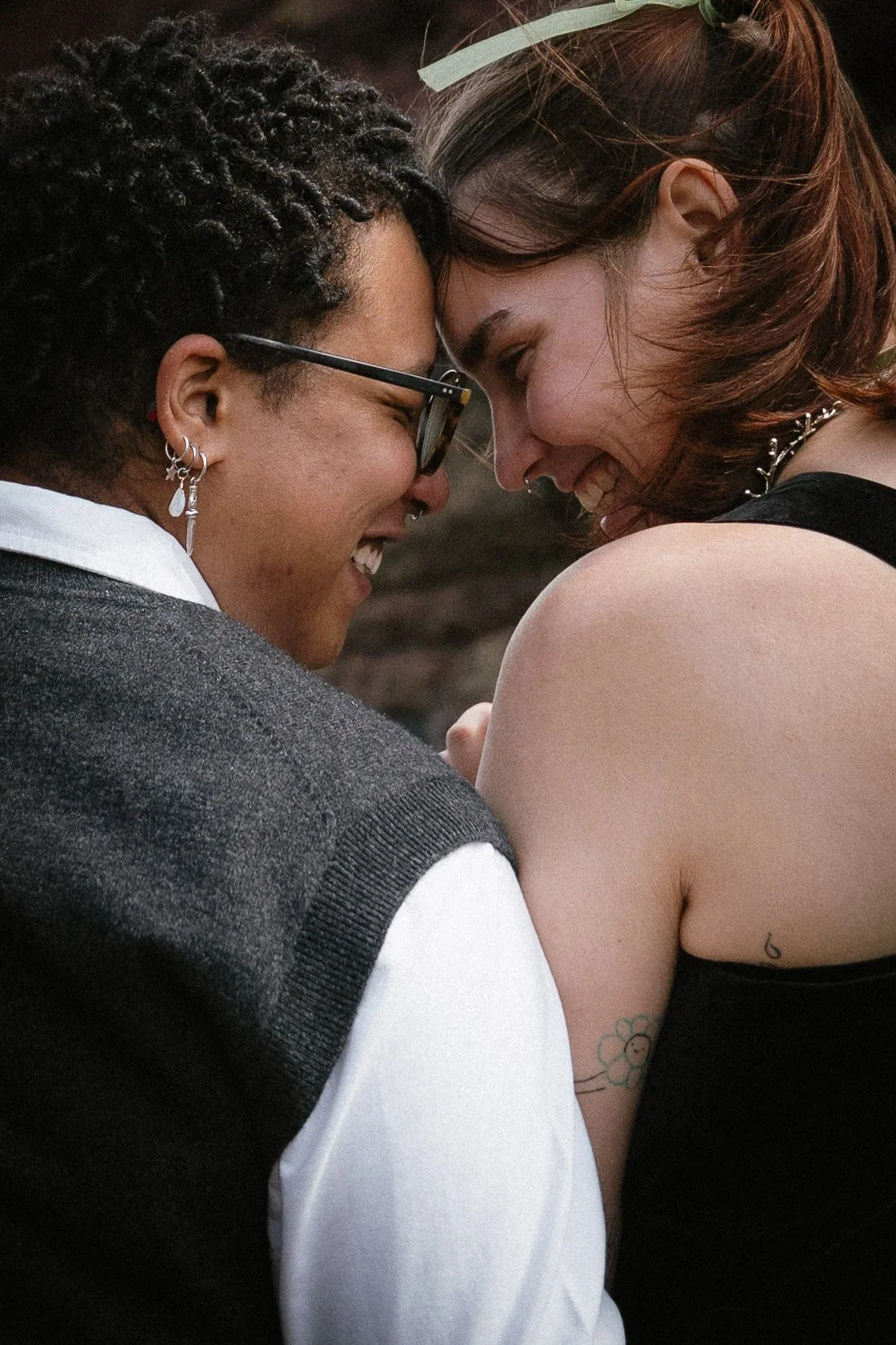 Two women with their foreheads touching, smiling and looking at each other affectionately - captured by an Edinburgh wedding photographer