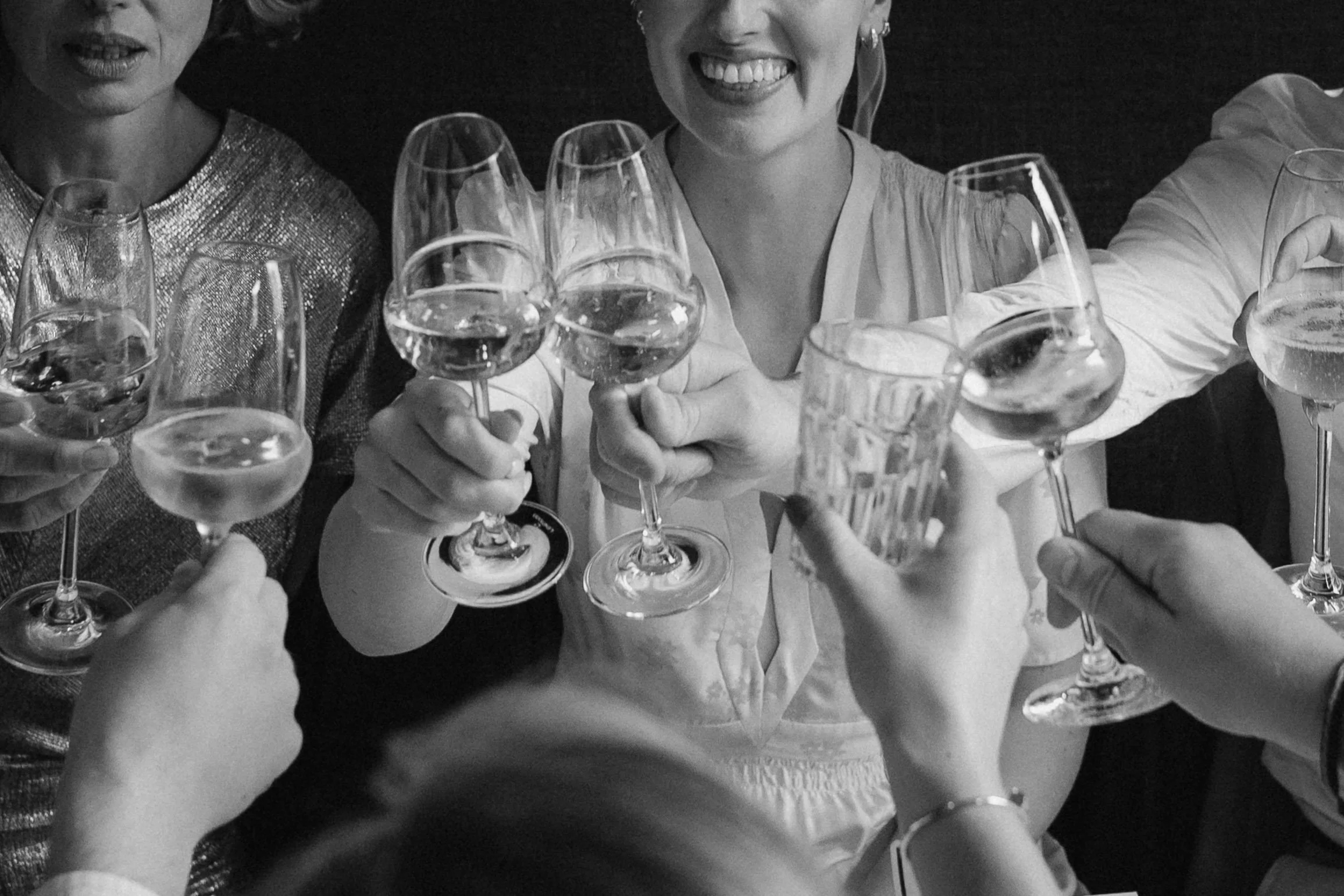 People raising glasses of wine and drinks for a toast at a celebration. - captured by an Edinburgh wedding photographer