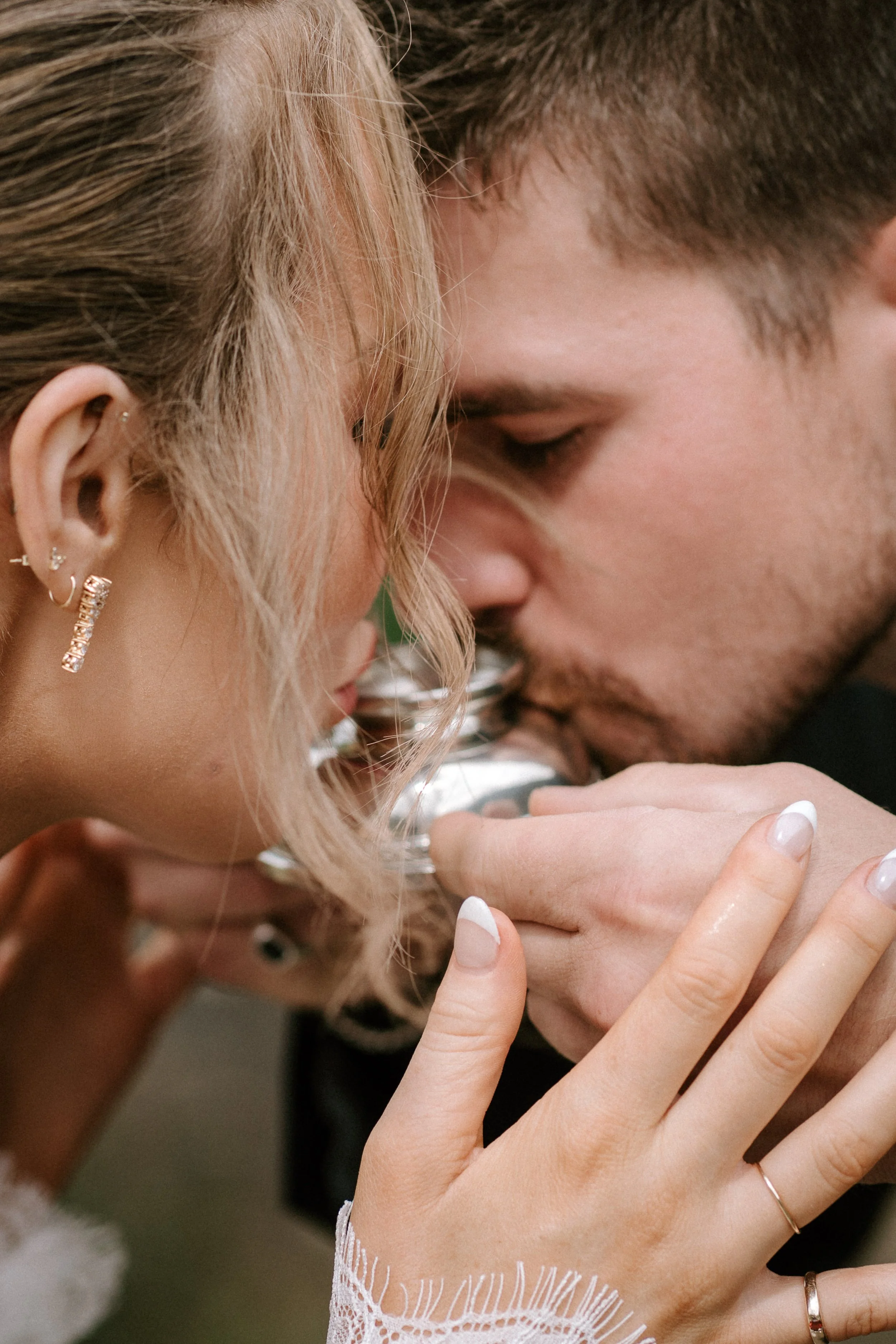 Close-up of an intimate moment where a woman and man touch foreheads and kiss, with the woman's hand gently holding the man's arm.