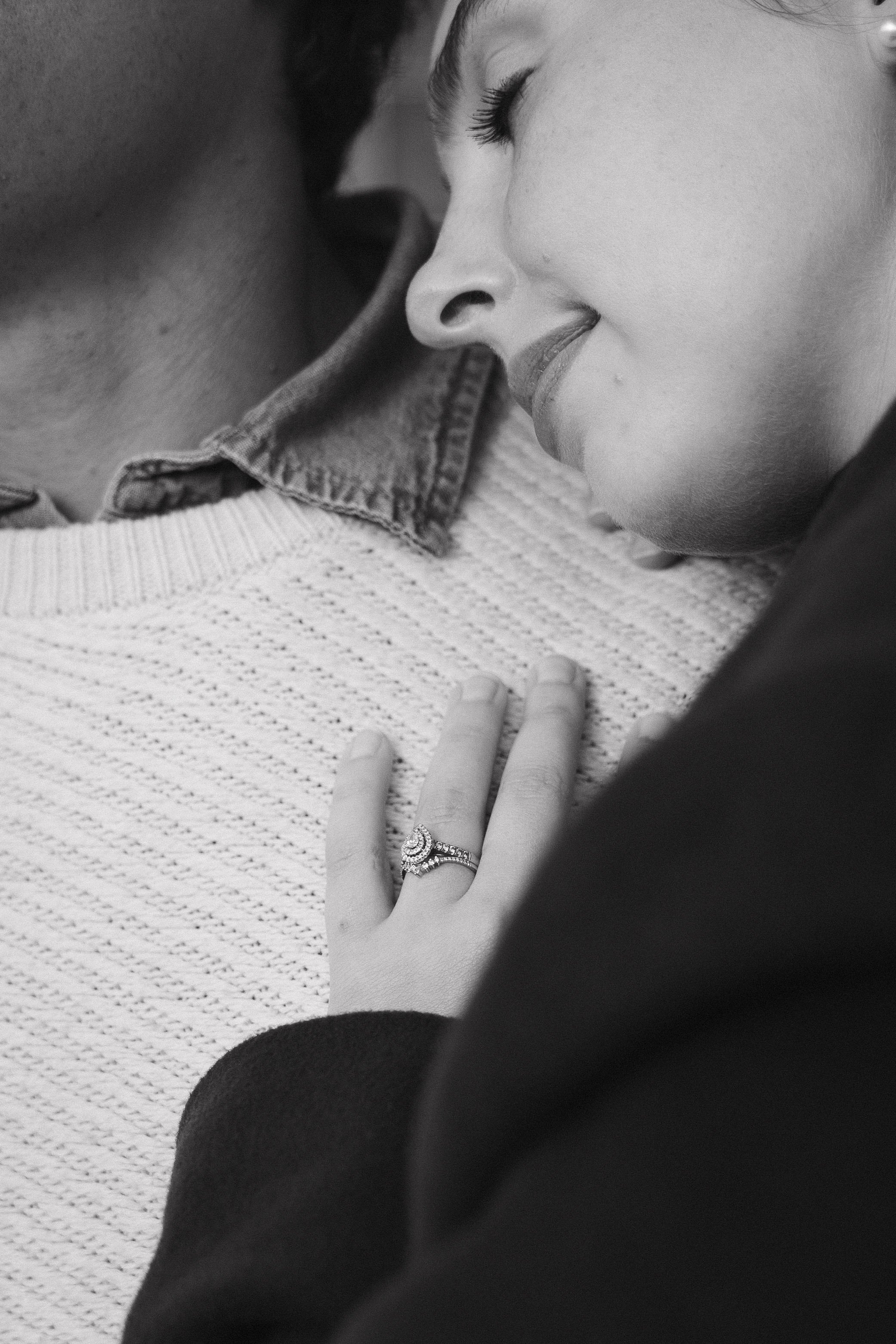 A couple sharing an intimate moment with their foreheads touching, a woman smiling with her eyes closed, showing a wedding ring on her finger. - captured by an Edinburgh wedding photographer