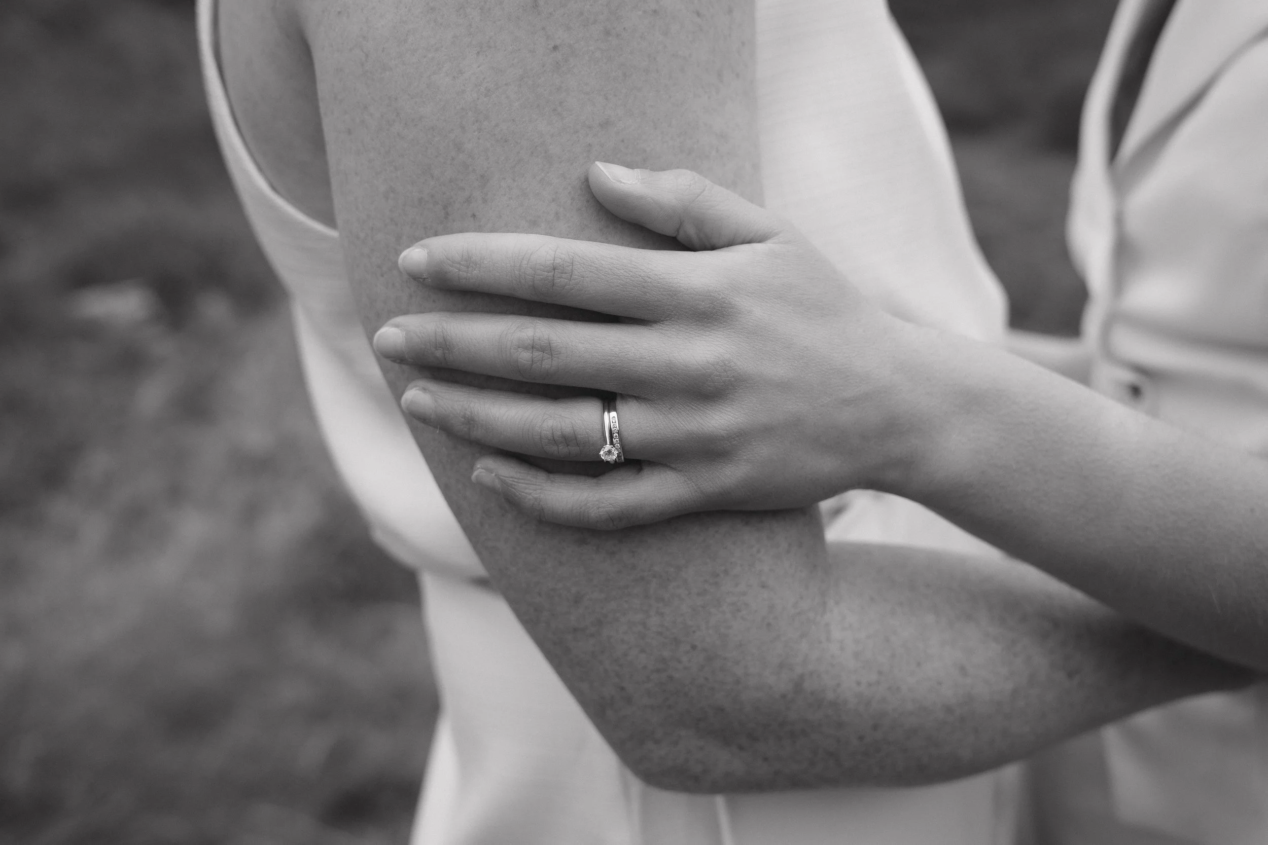 A black-and-white close-up of a woman's arm with a wedding ring on her finger - captured by an Edinburgh wedding photographer