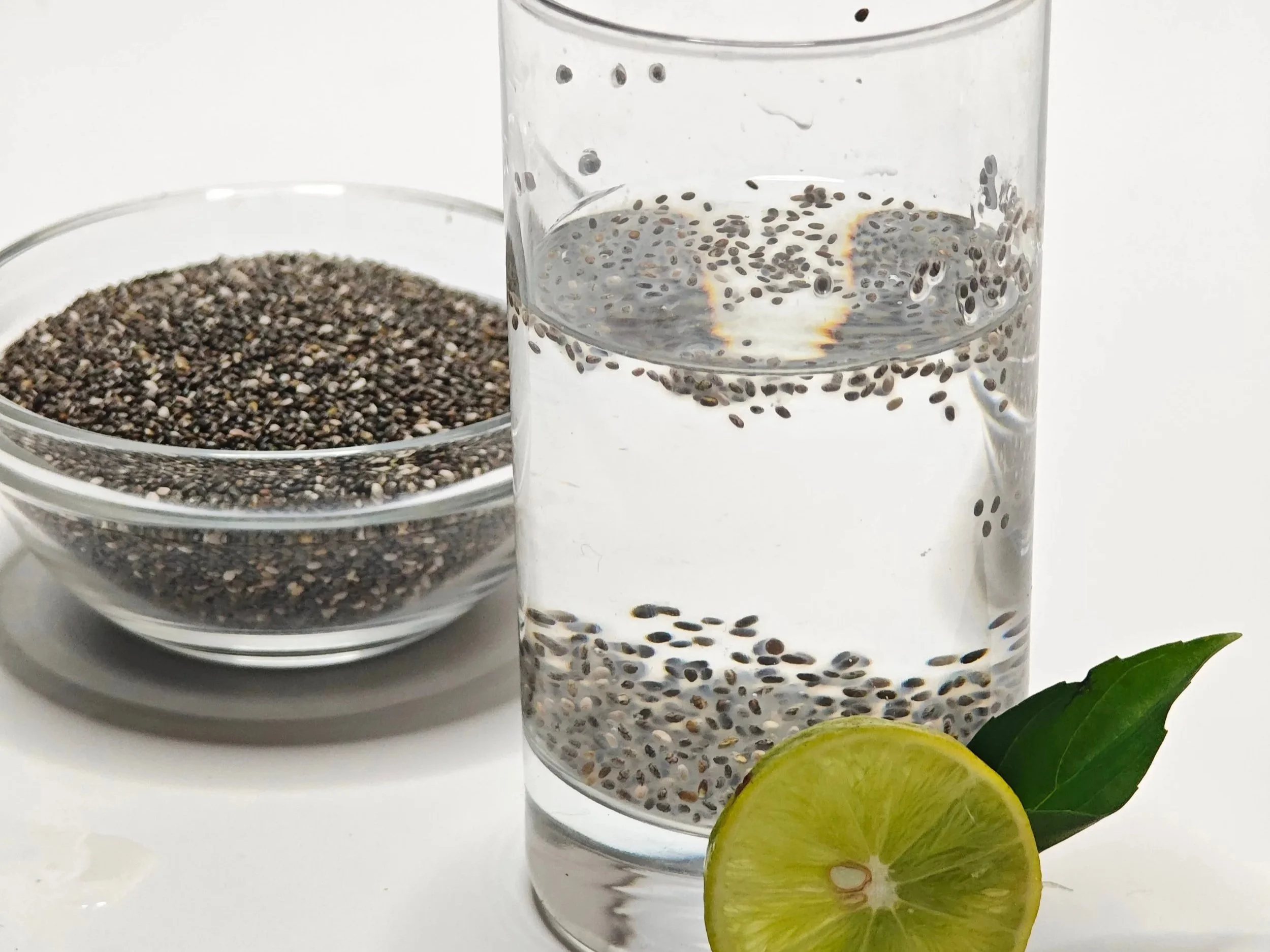 Glass of water with soaked chia seeds and a slice of fresh lemon, illustrating a simple daily ritual to support hydration and digestive health.