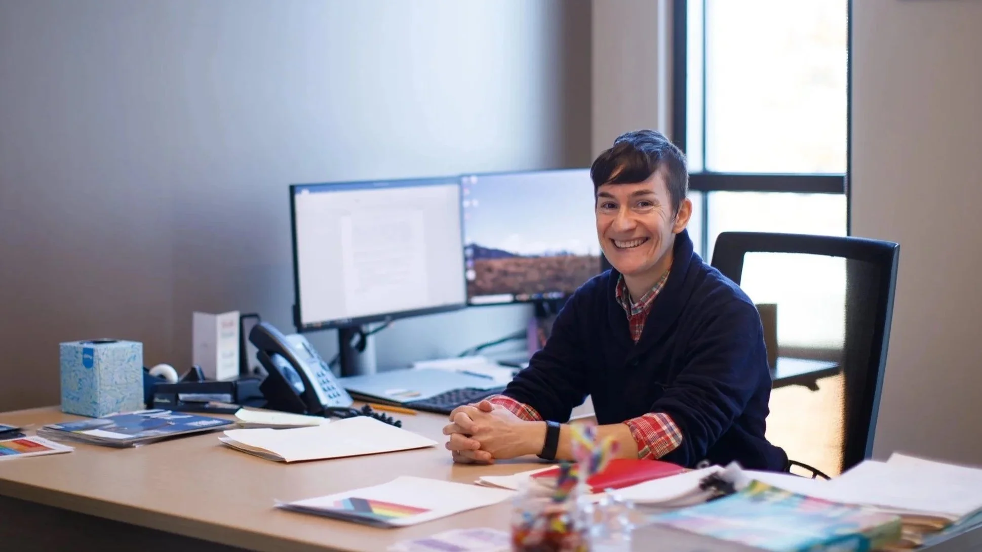 Photo of Litav sitting at desk, smiling.