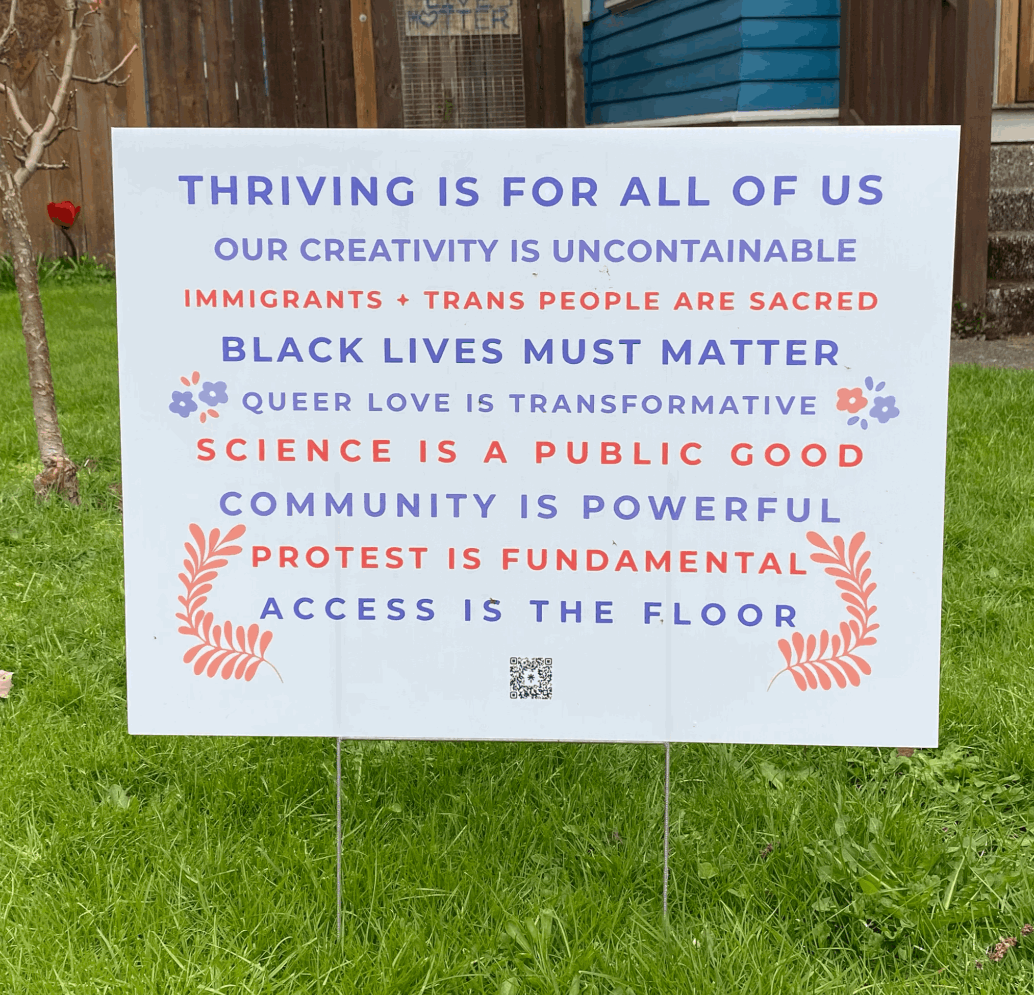 Photo of Thriving Is For All Of Us yard sign in a grassy yard