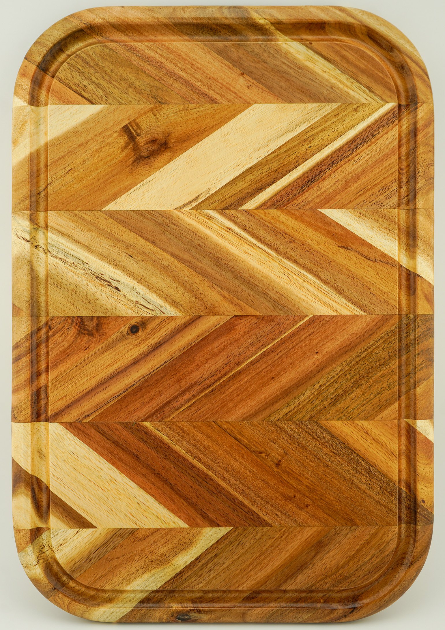 A rectangular wooden tray with rounded corners, featuring a chevron pattern of various natural wood shades.
