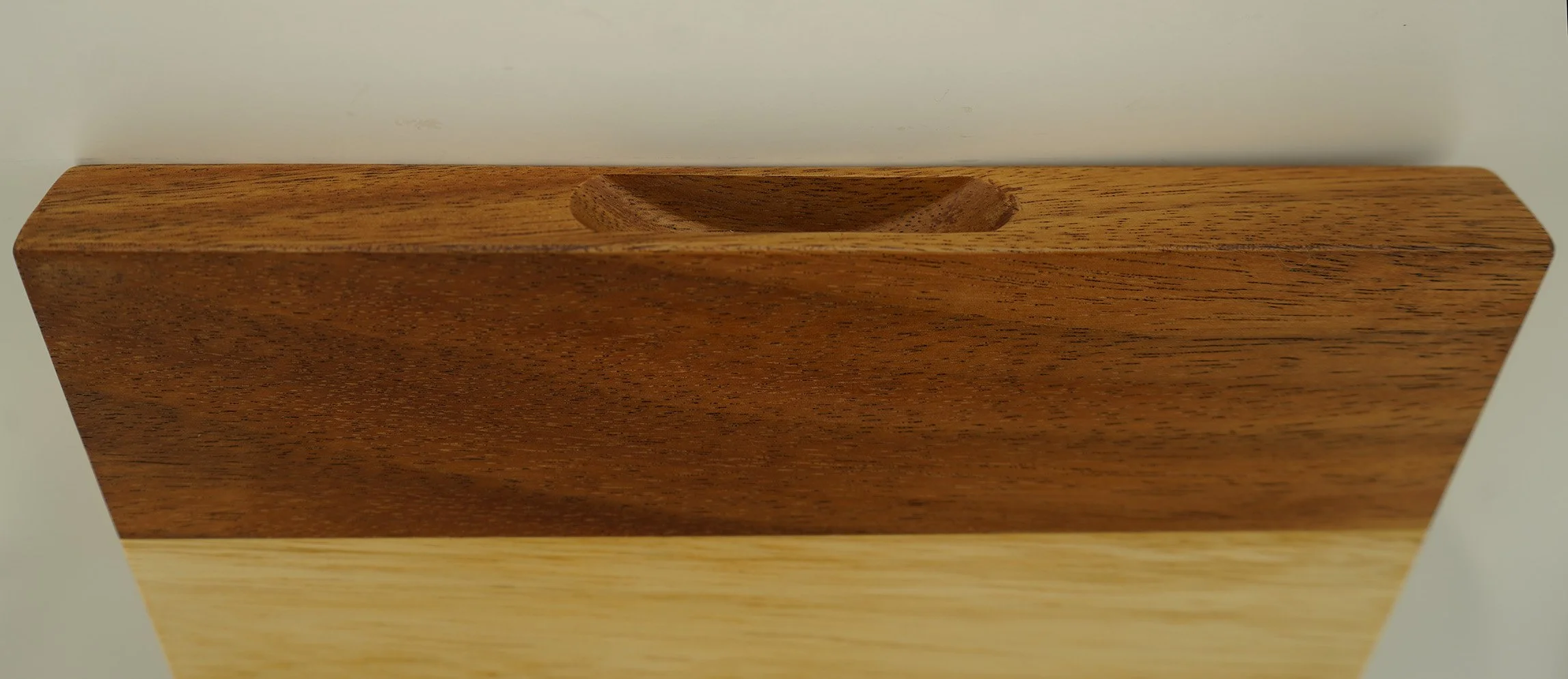 Close-up of a wooden tissue box holder with a rectangular opening at the top, placed on a white surface.