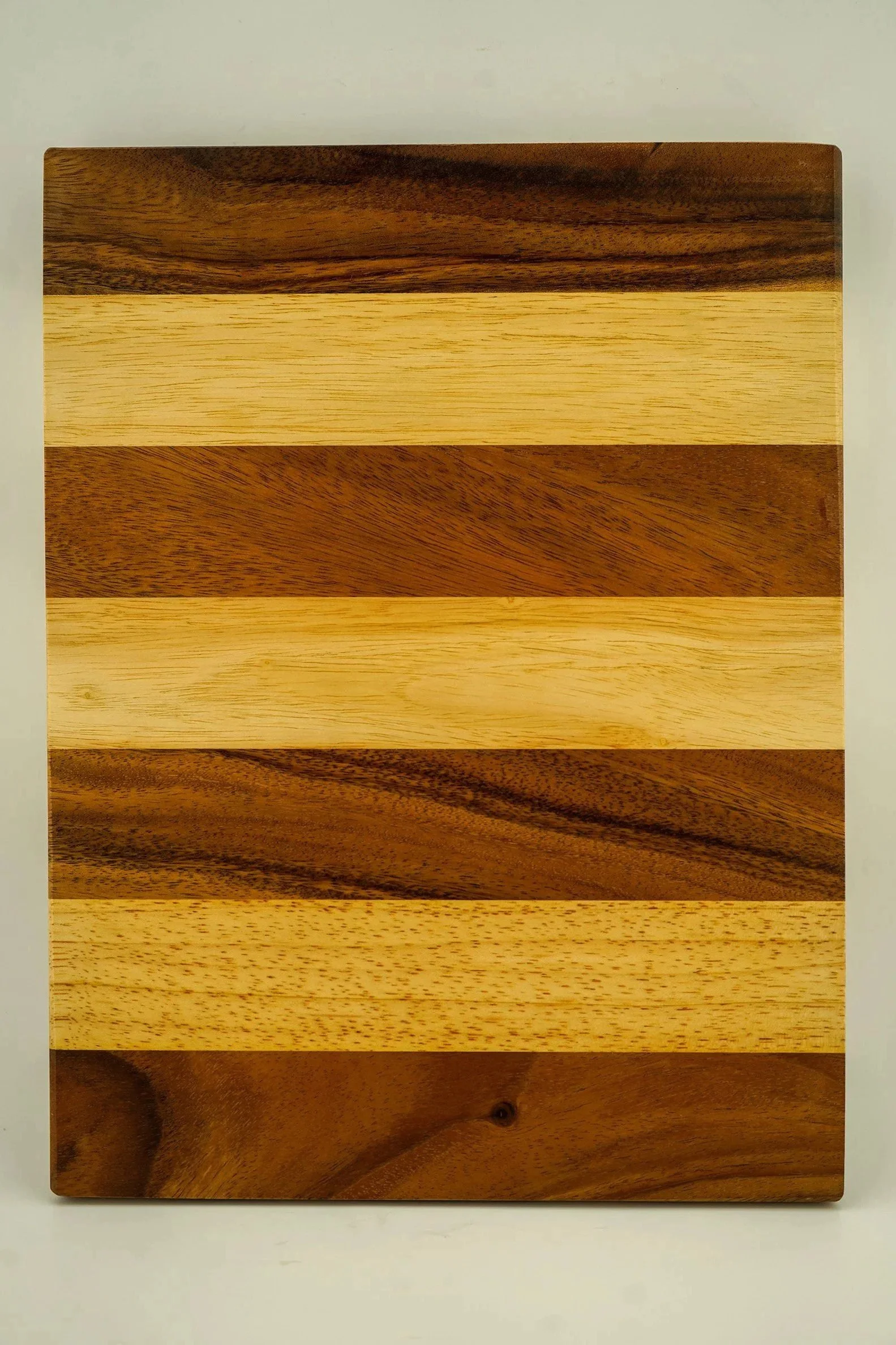 Wooden cutting board with alternating light and dark stripes
